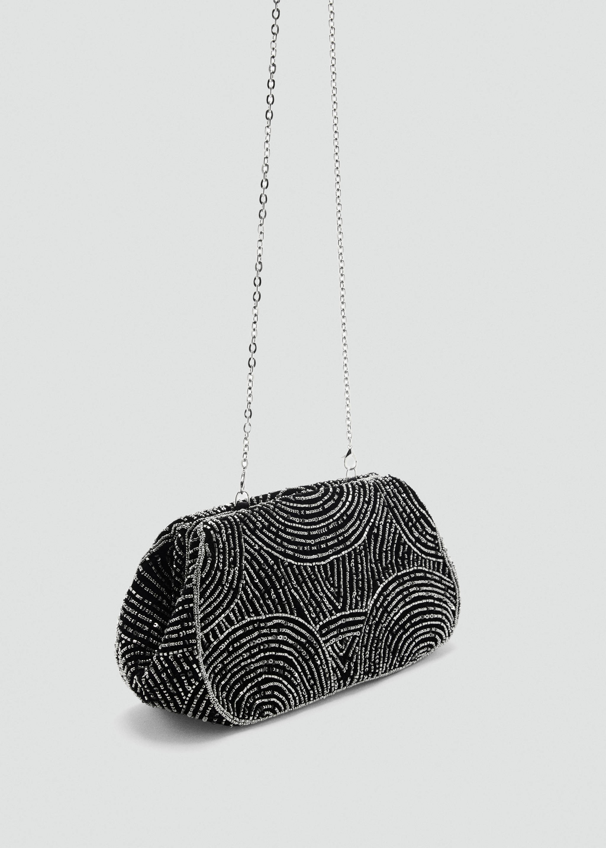 Black beaded handbag with silver geometric arches and a metal chain strap.