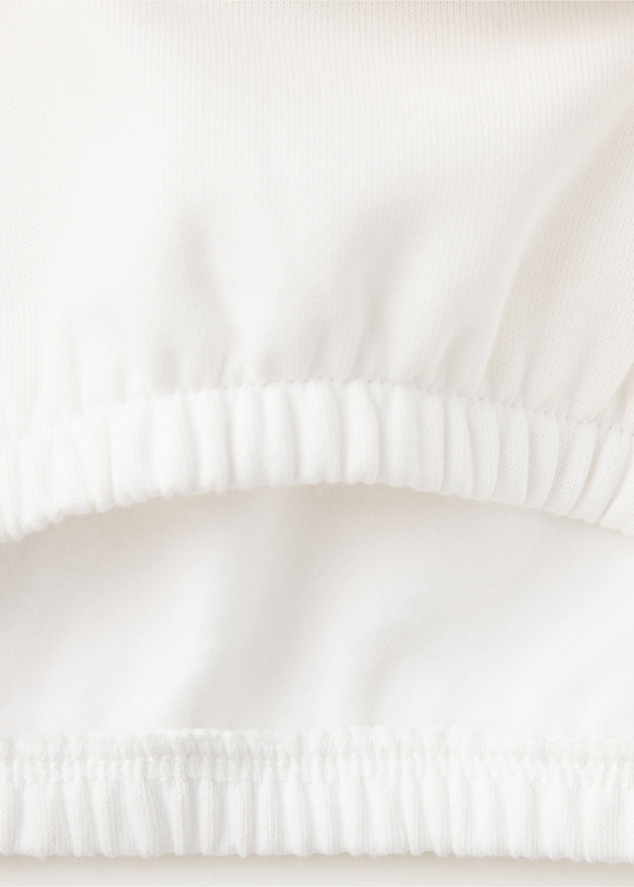 Primer plano del tejido y del bajo elástico en una sudadera blanca., Blanco roto. Ref: 37079215-00.