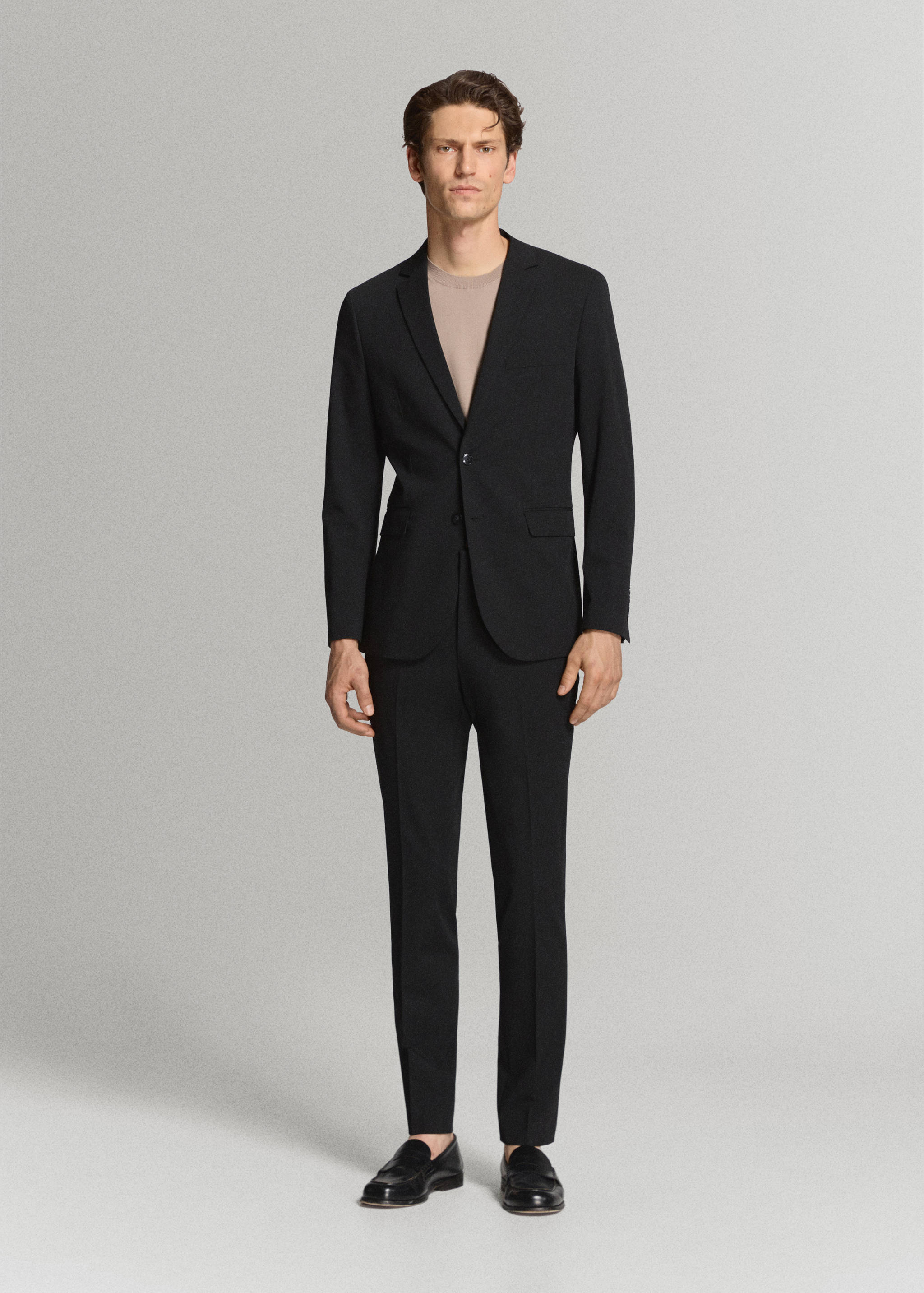 Black slim-fit trousers worn with a matching black blazer.