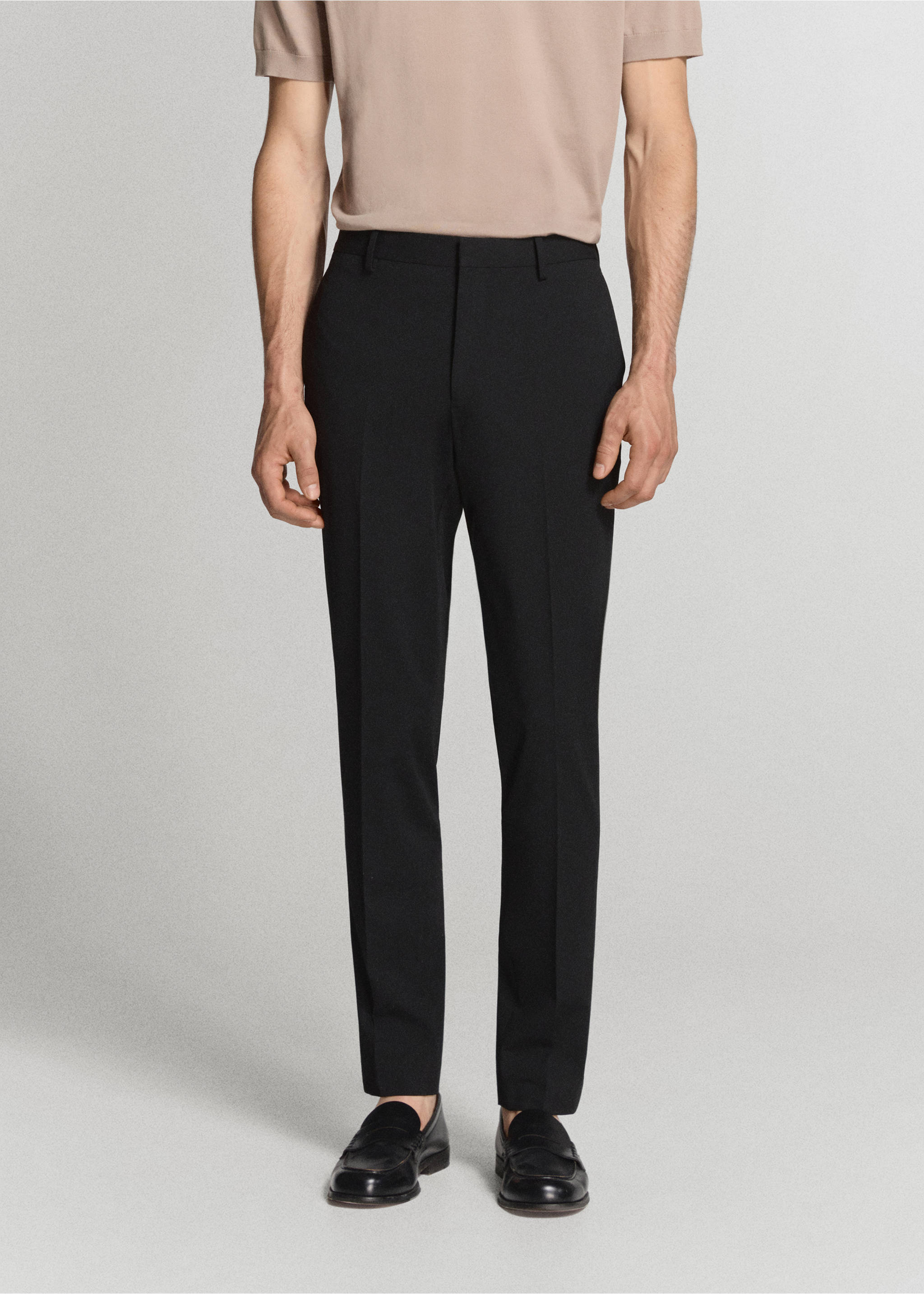 Black tailored trousers with belt loops and pressed creases, worn with a beige t-shirt., Black. Ref: 37081356-01.