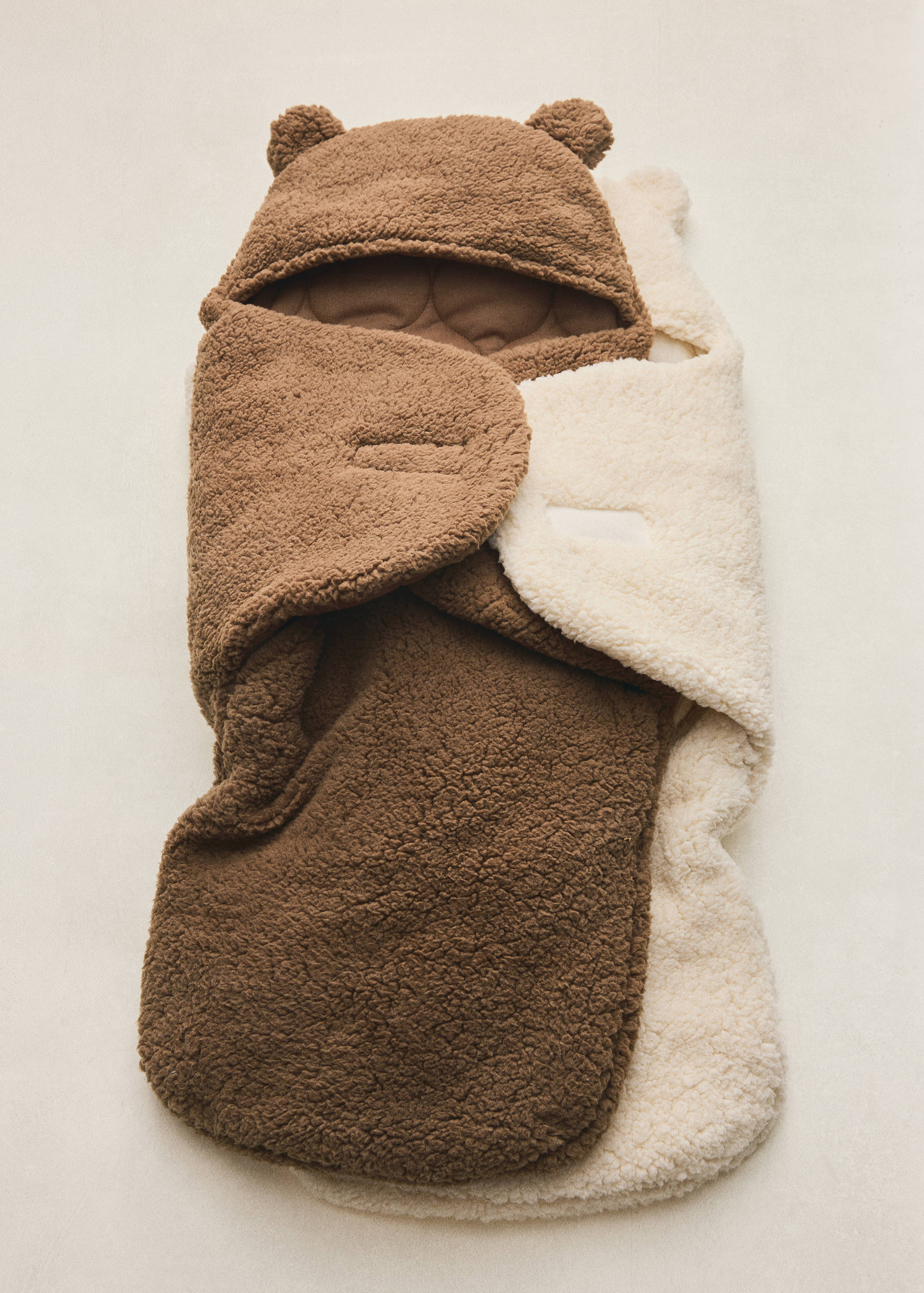 Brown faux-shearling baby pram bag with a bear-ear hood.