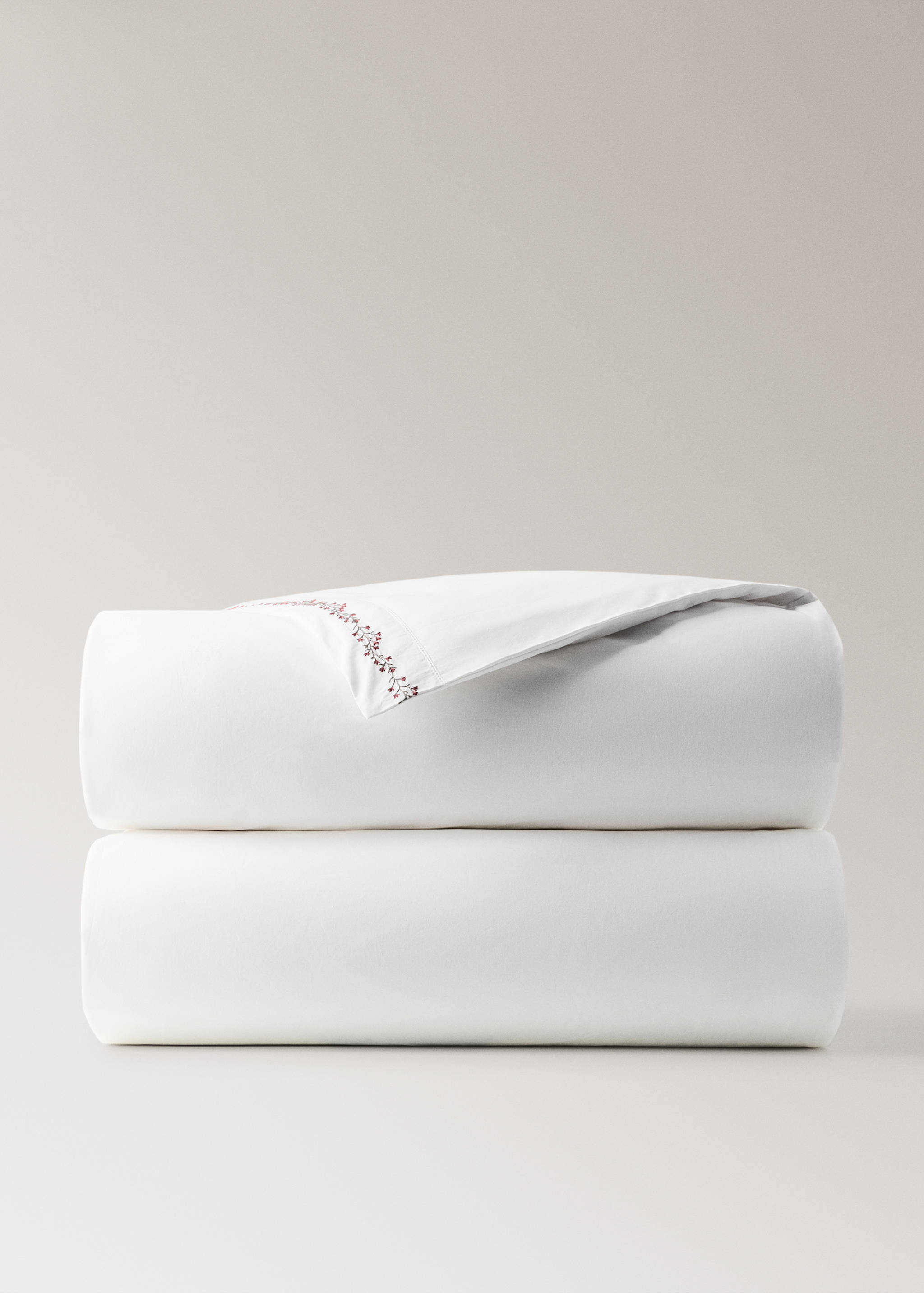 White duvet cover with delicate red floral embroidery.