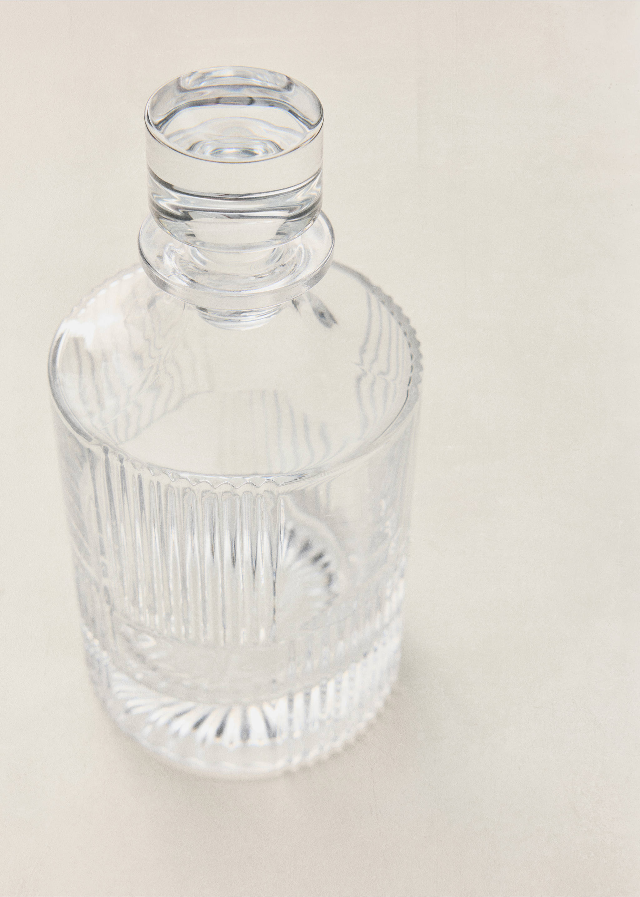 Clear glass bottle with vertical fluted texture and stopper., Black. Ref: 37083866-00.