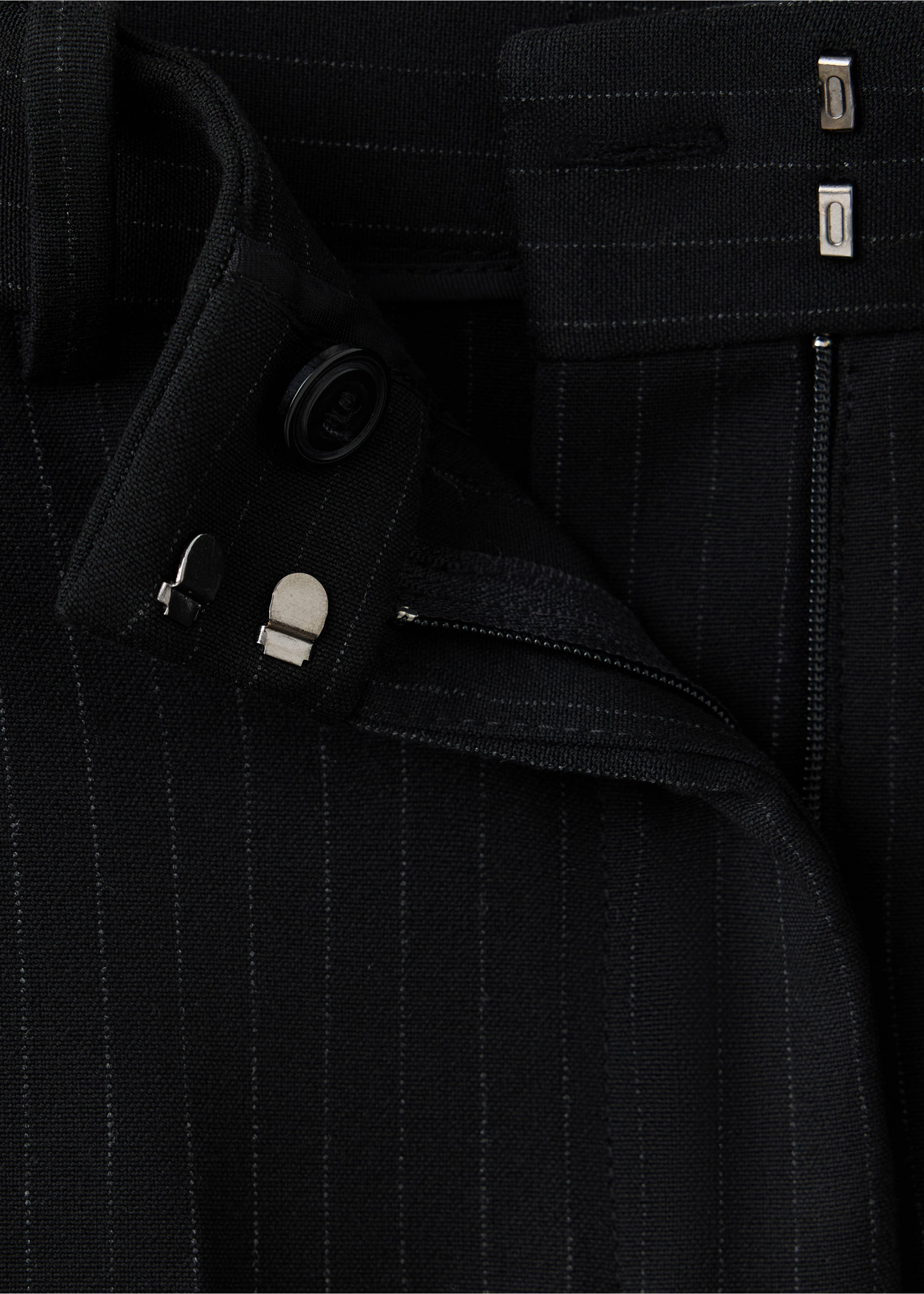Close-up of black pinstriped trousers showing the waistband and fastening details., Black. Ref: 37084111-00.