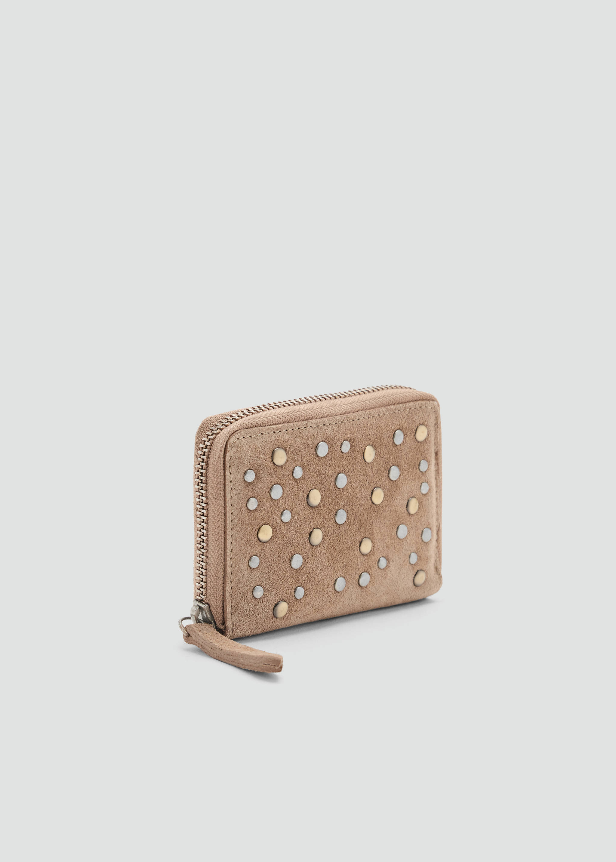 Beige suede wallet with mixed metallic studs and zip-around closure in a three-quarter view.