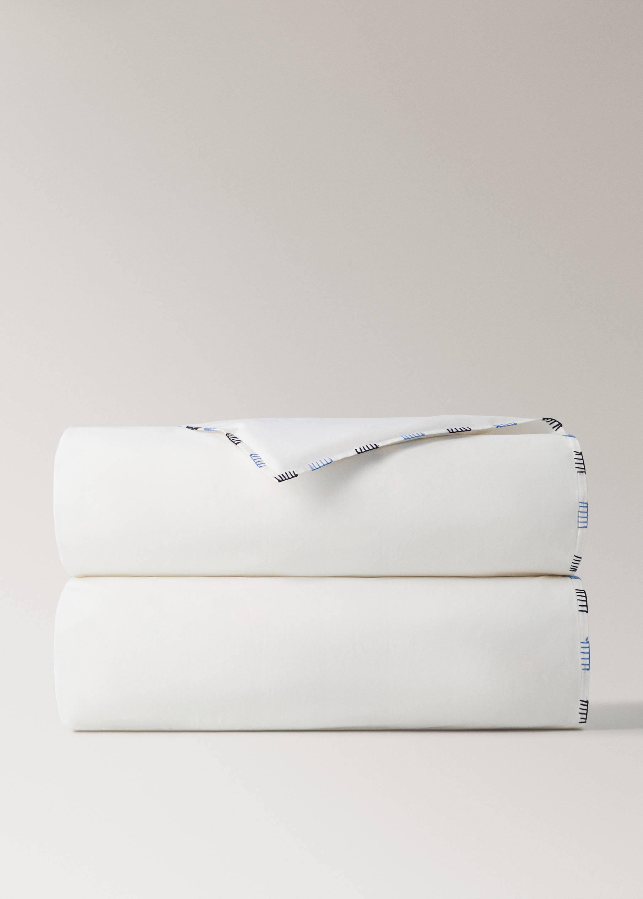 White duvet cover with a blue and black embroidered border.