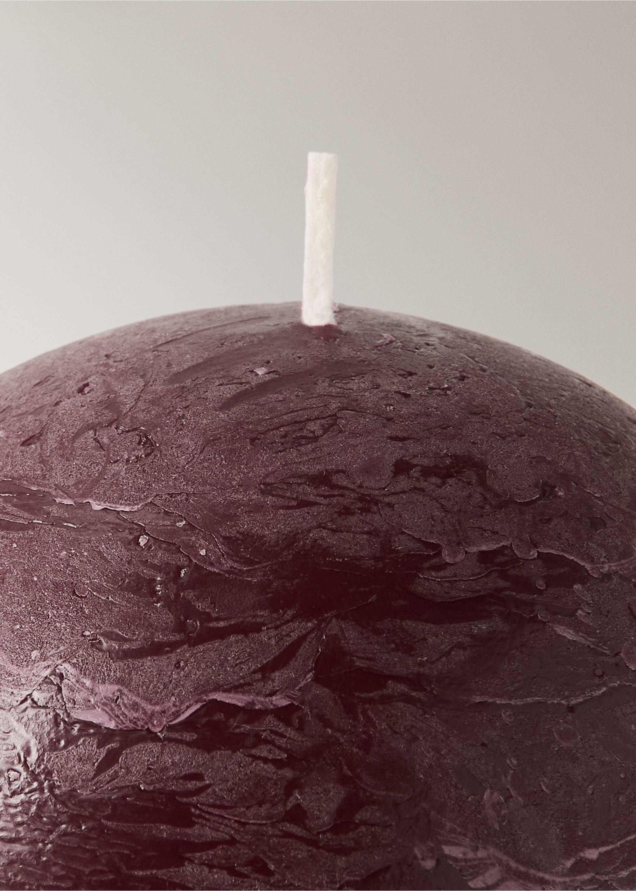 Close-up of a textured dark burgundy candle showing its white wick., Maroon. Ref: 37085881-00.