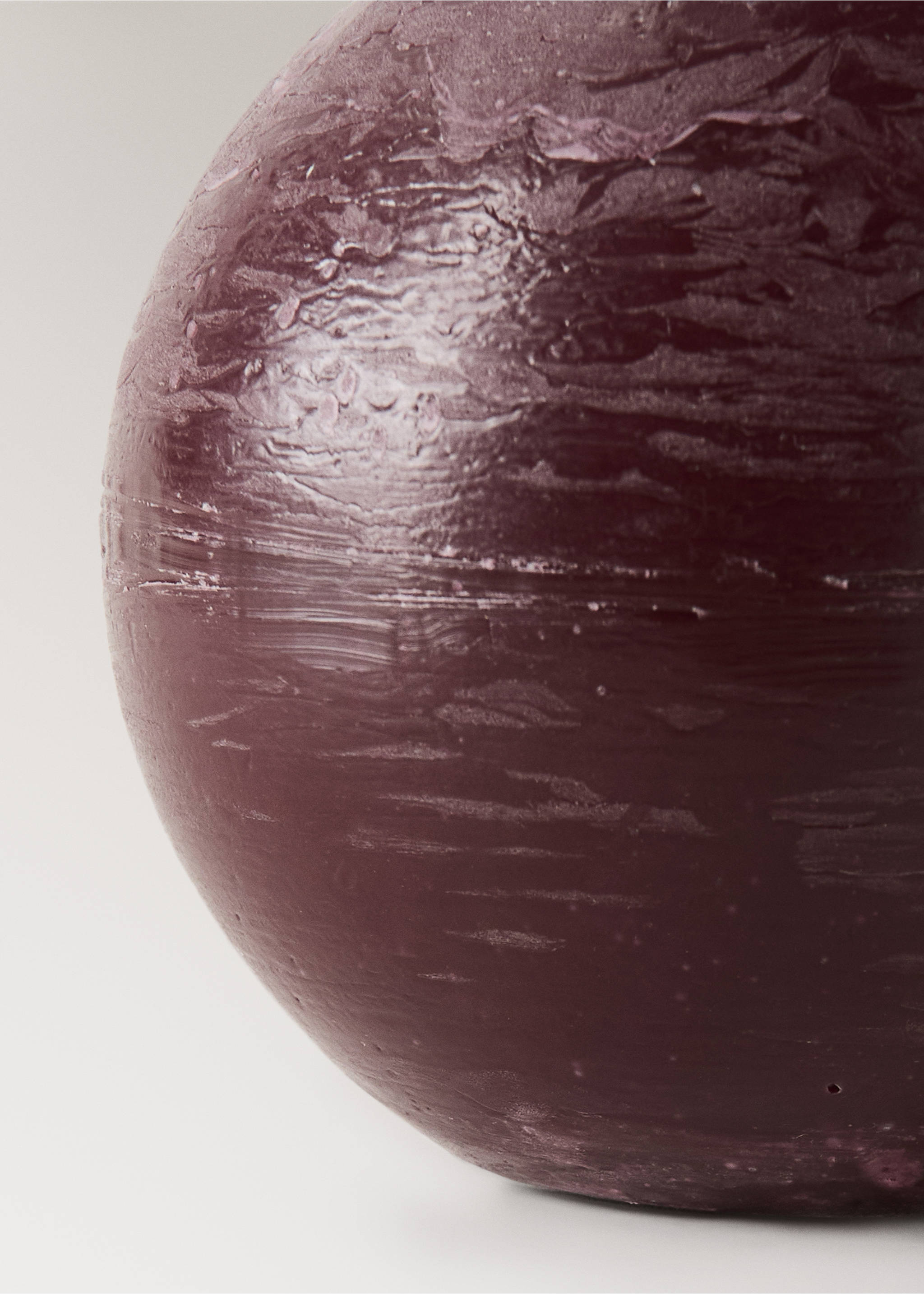 Close-up of a dark purple spherical candle with a textured surface., Maroon. Ref: 37085881-00.