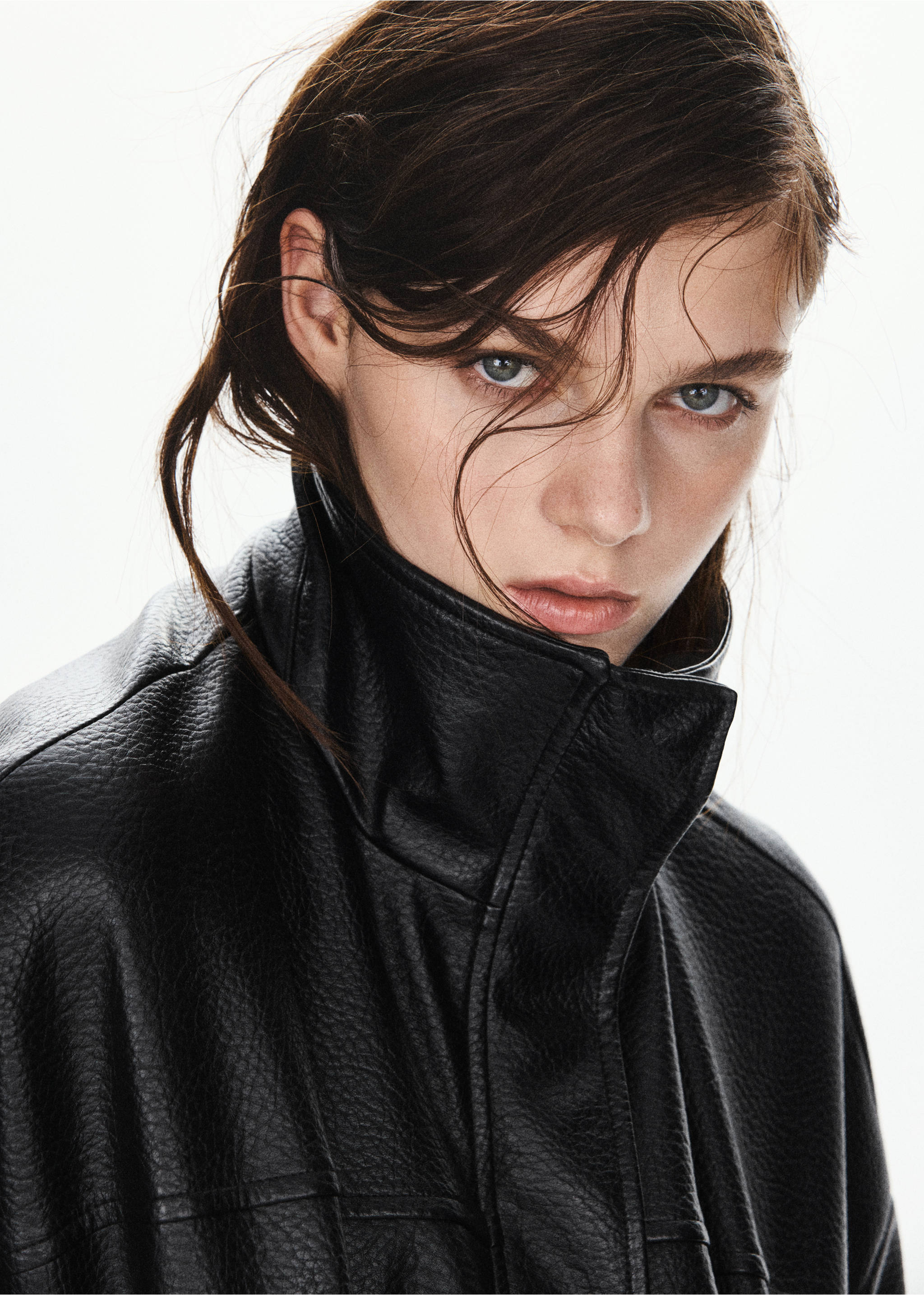 Close-up of a black textured jacket with a high collar, worn by a model., Black. Ref: 37086000-01.