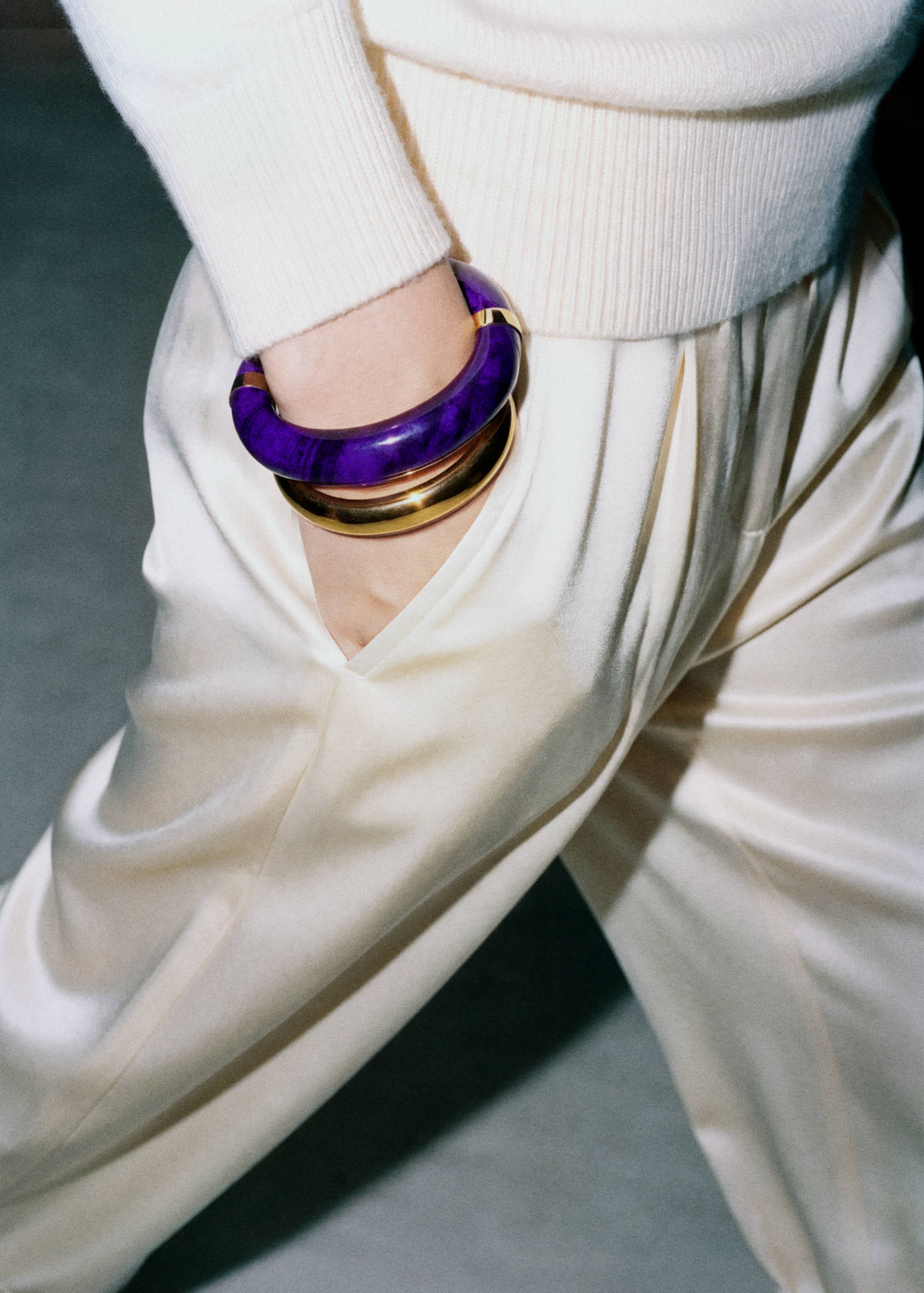 Deep purple patterned and gold-tone metal bangles stacked on a wrist.