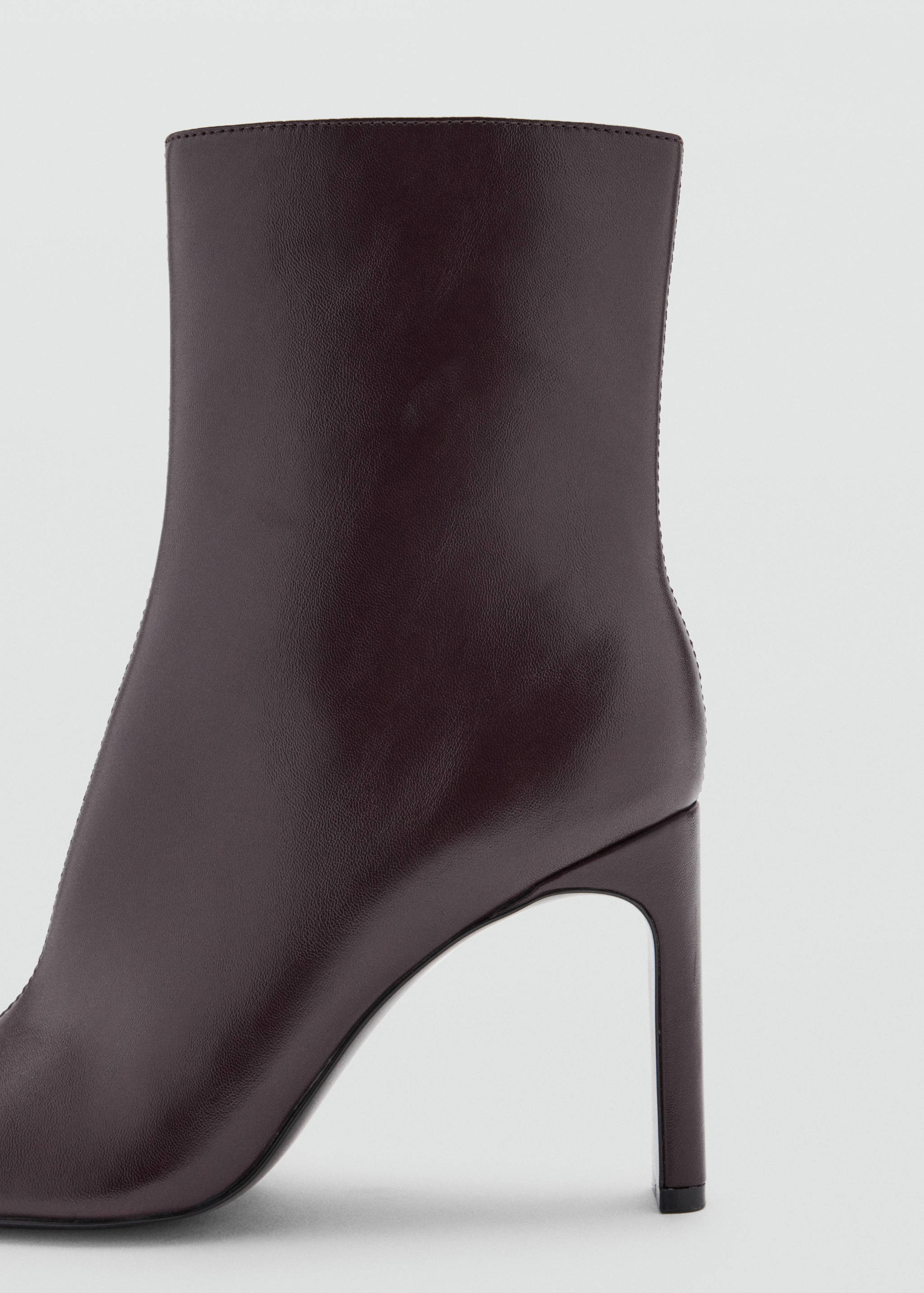 Close-up of a burgundy ankle boot with a stiletto heel.
