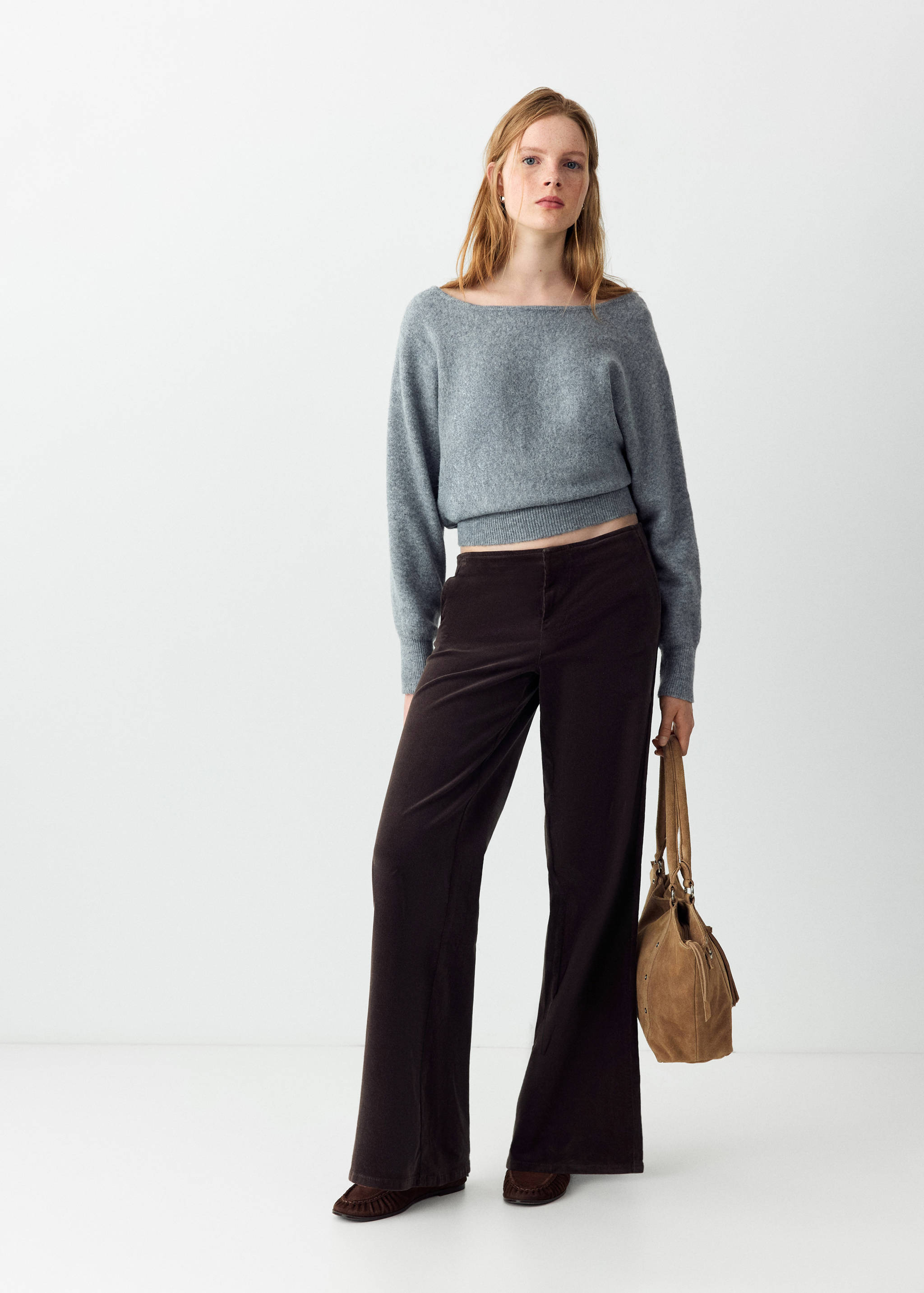 Dark brown flared trousers worn with a grey boatneck sweater.