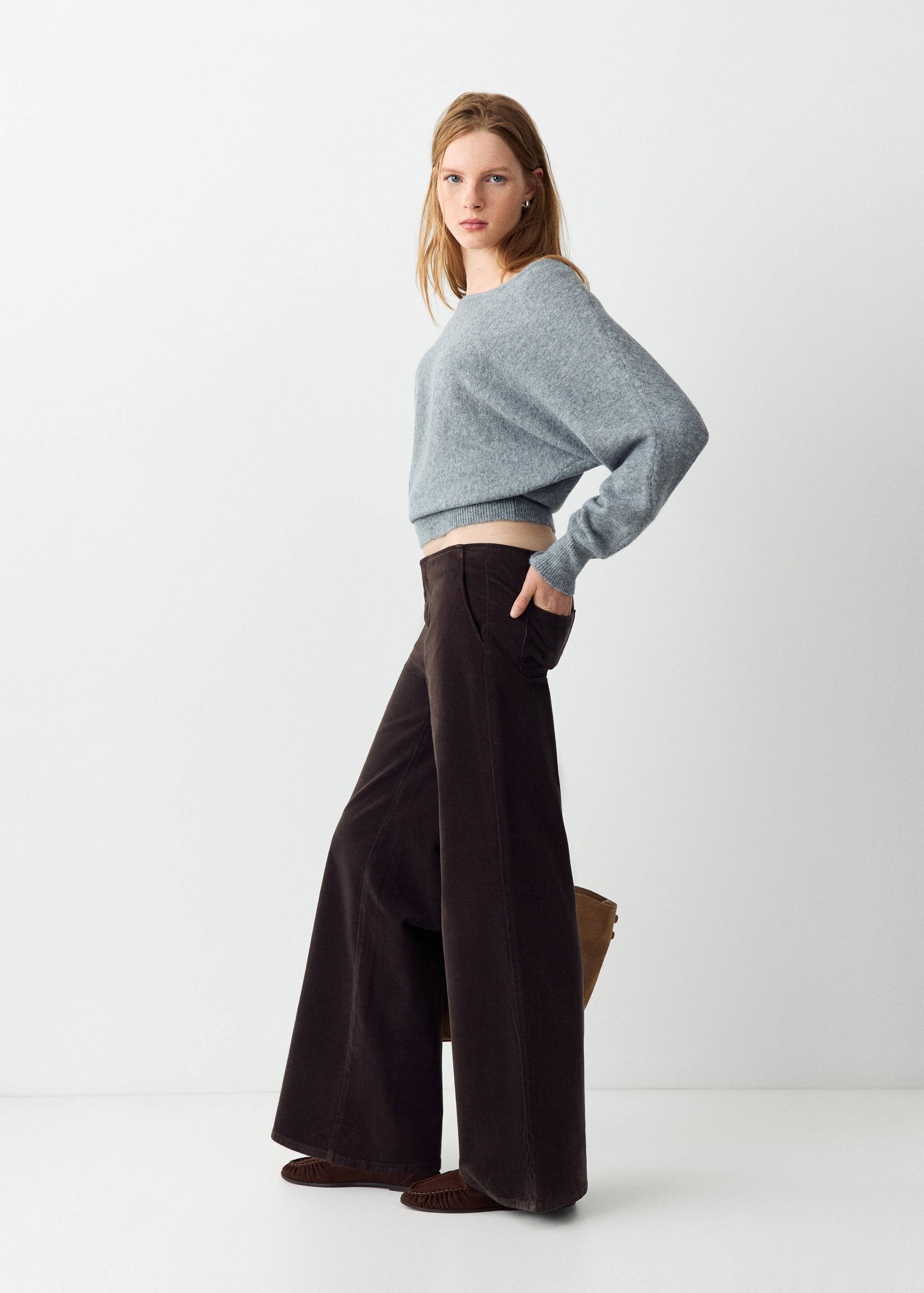 Dark brown wide-leg trousers worn with a light grey cropped knitted jumper.