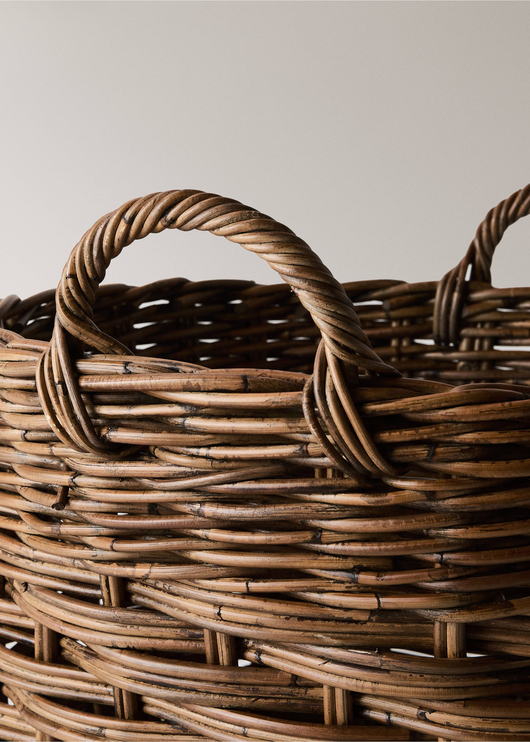 Close-up of a brown woven rattan basket showing the textured weave and handle detail., Brown. Ref: 37086729-00.