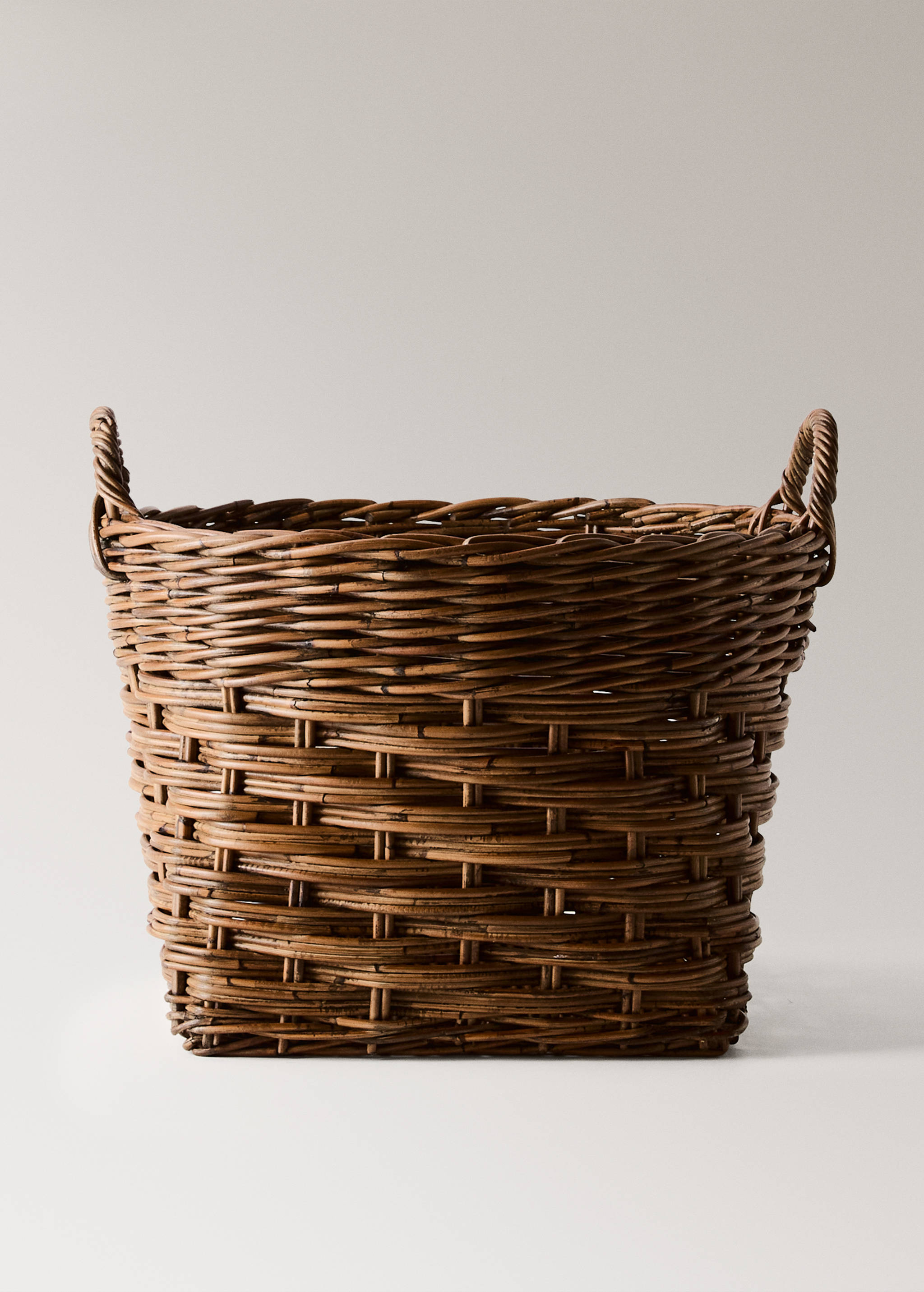 Brown woven rattan basket with integrated loop handles.