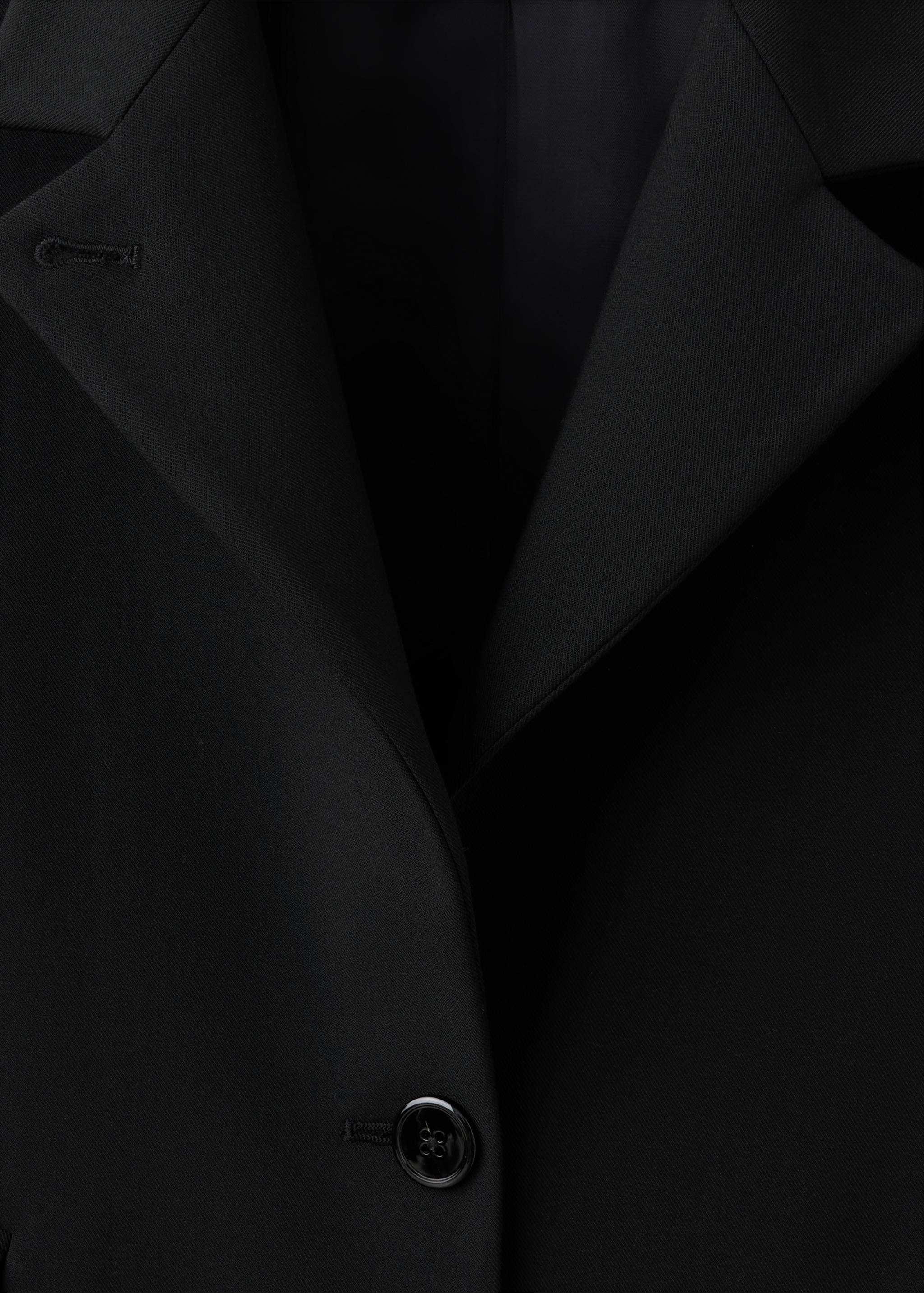 Close-up of a black blazer with notched lapels and a button., Black. Ref: 37086733-00.