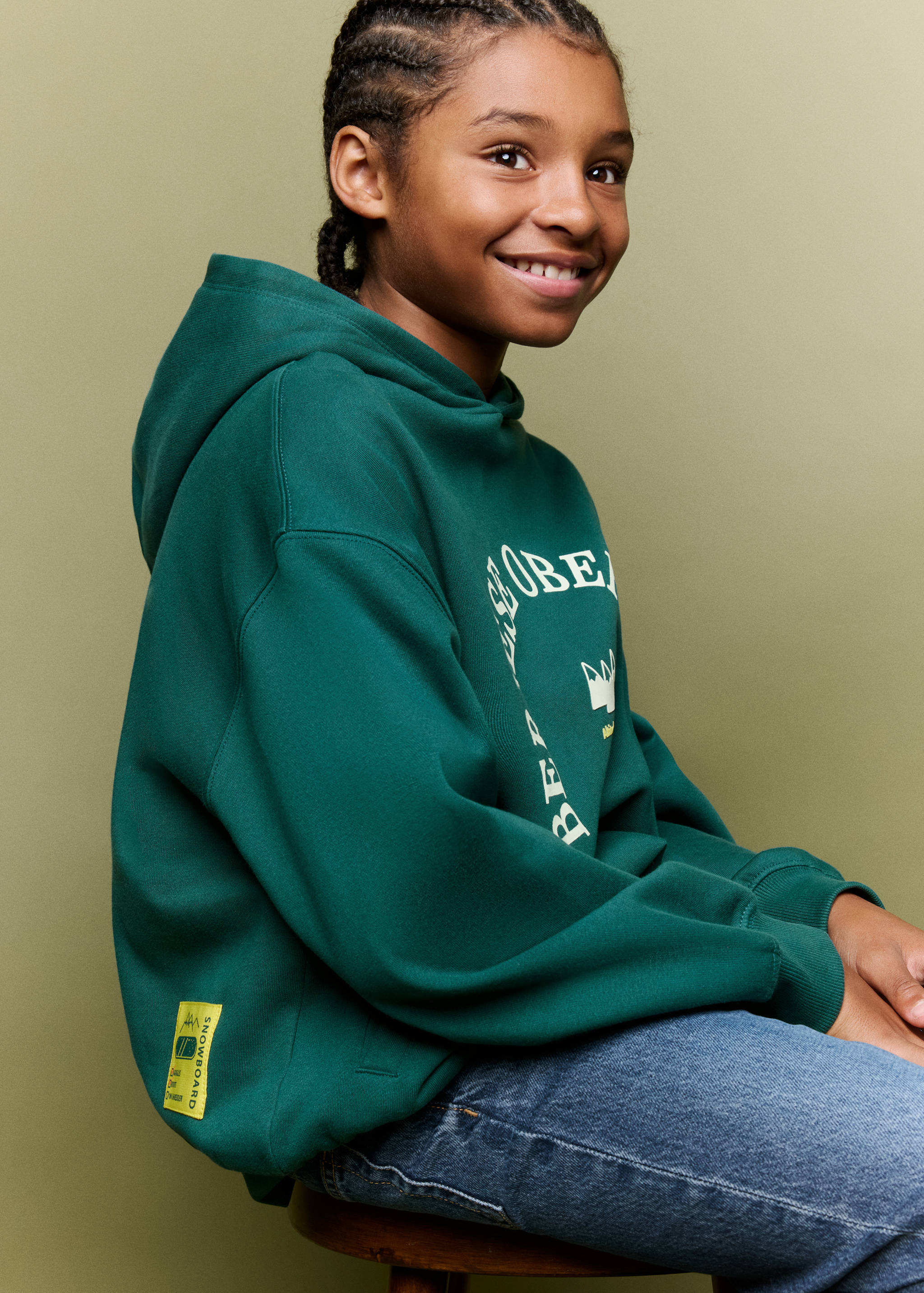 Dark green hooded sweatshirt with dropped shoulders and ribbed cuffs.