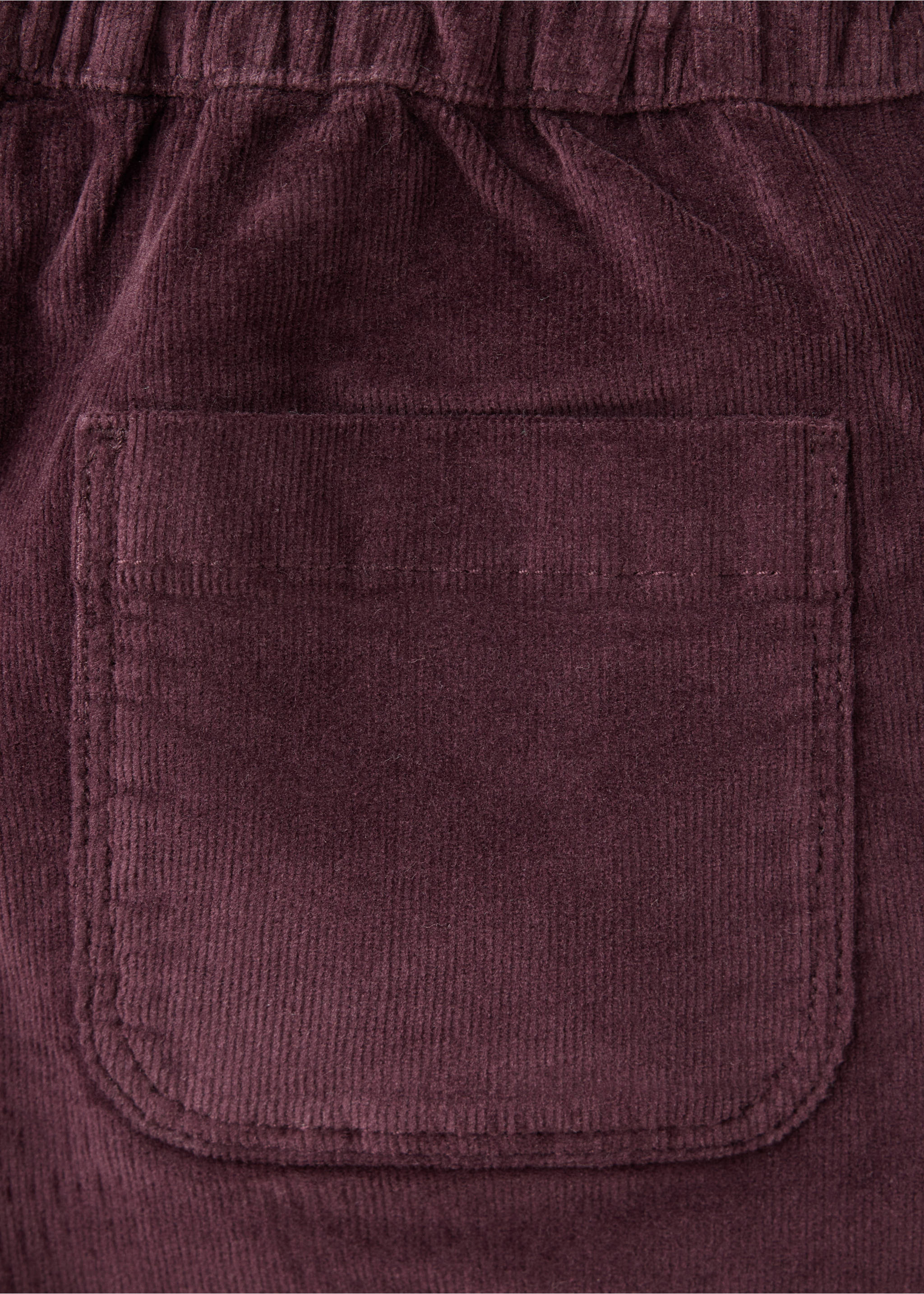 Close-up of dark burgundy corduroy trousers showing a back pocket., Maroon. Ref: 37087124-00.