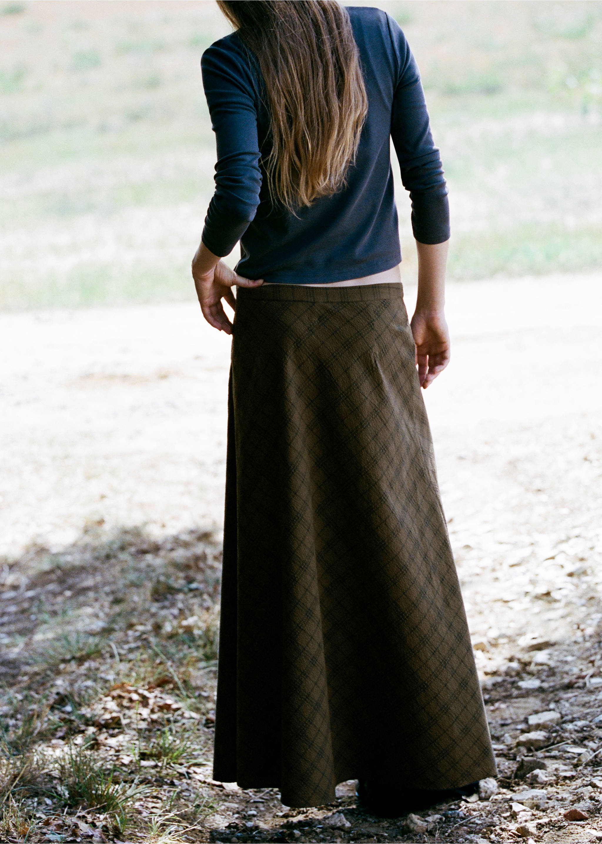 Long olive green plaid skirt seen from the back, paired with a dark grey top., Green. Ref: 37087127-00.