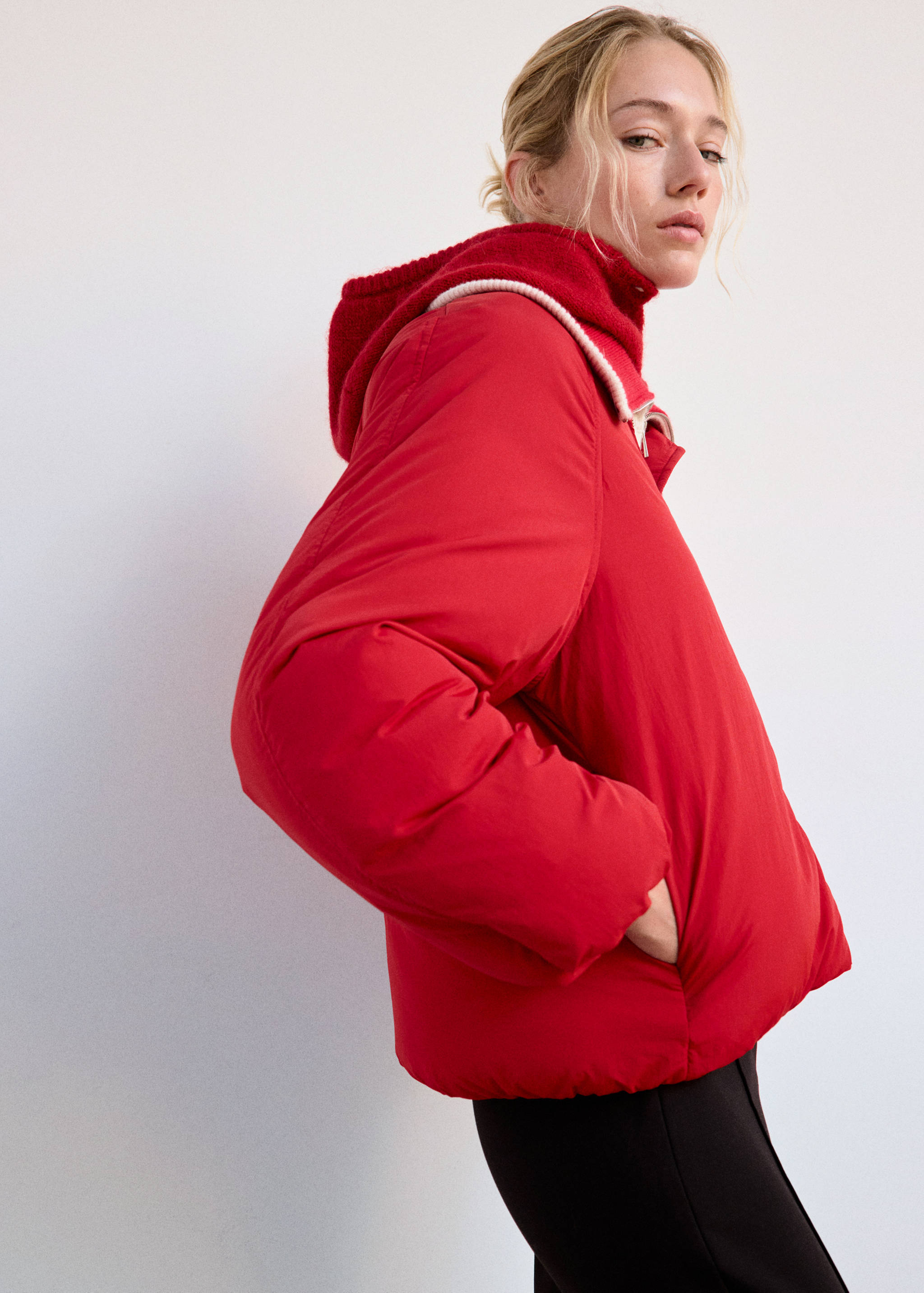 Red quilted anorak with a hooded high collar and white trim.