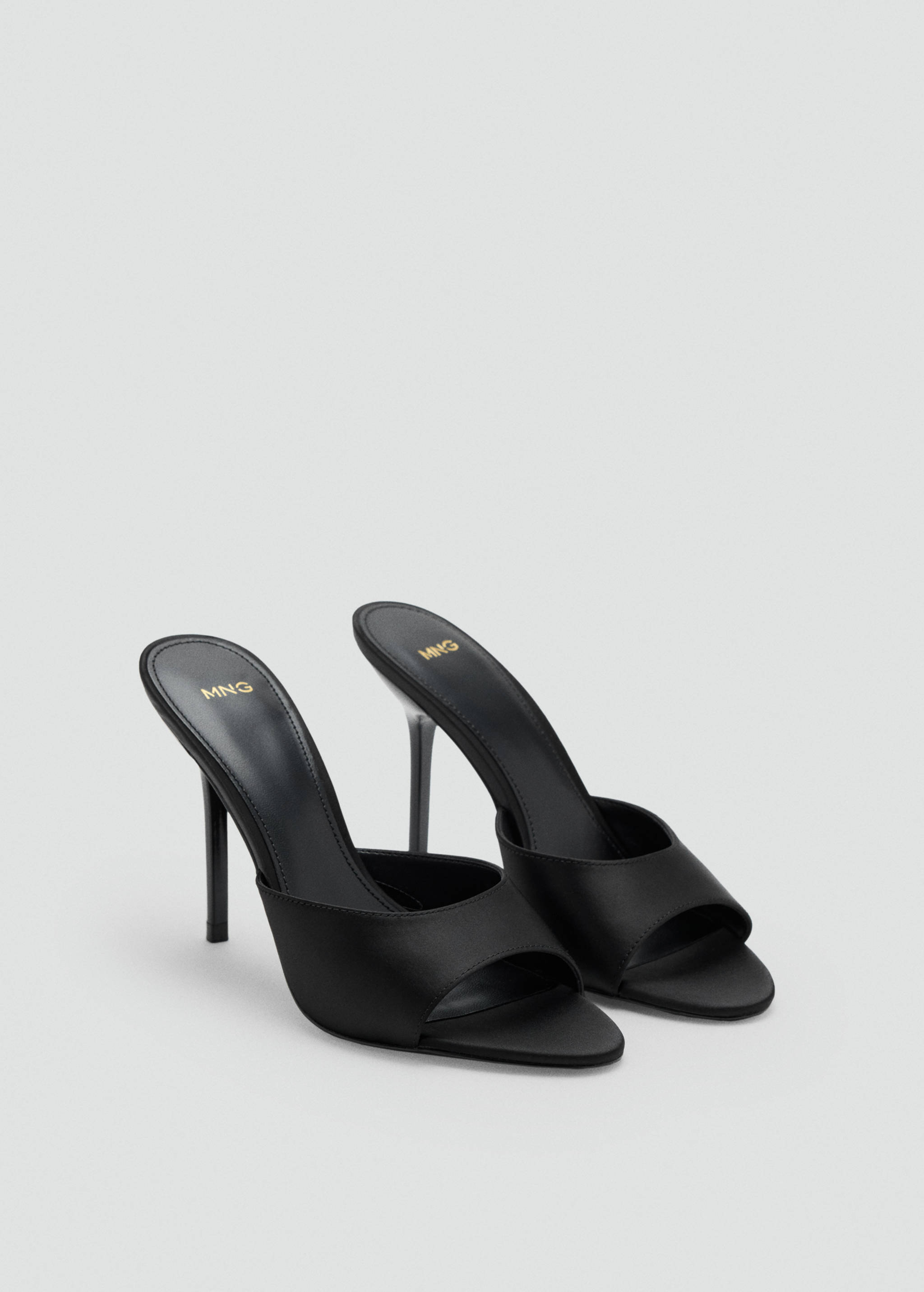 Black heeled sandals with wide front strap and stiletto heel.