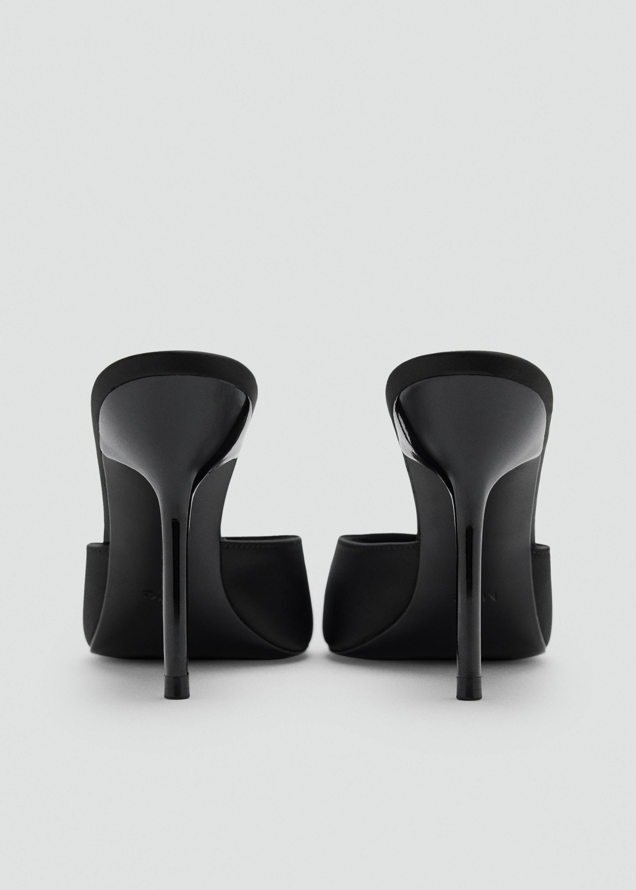 Black heeled sandals with thin stiletto heels, viewed from the back.