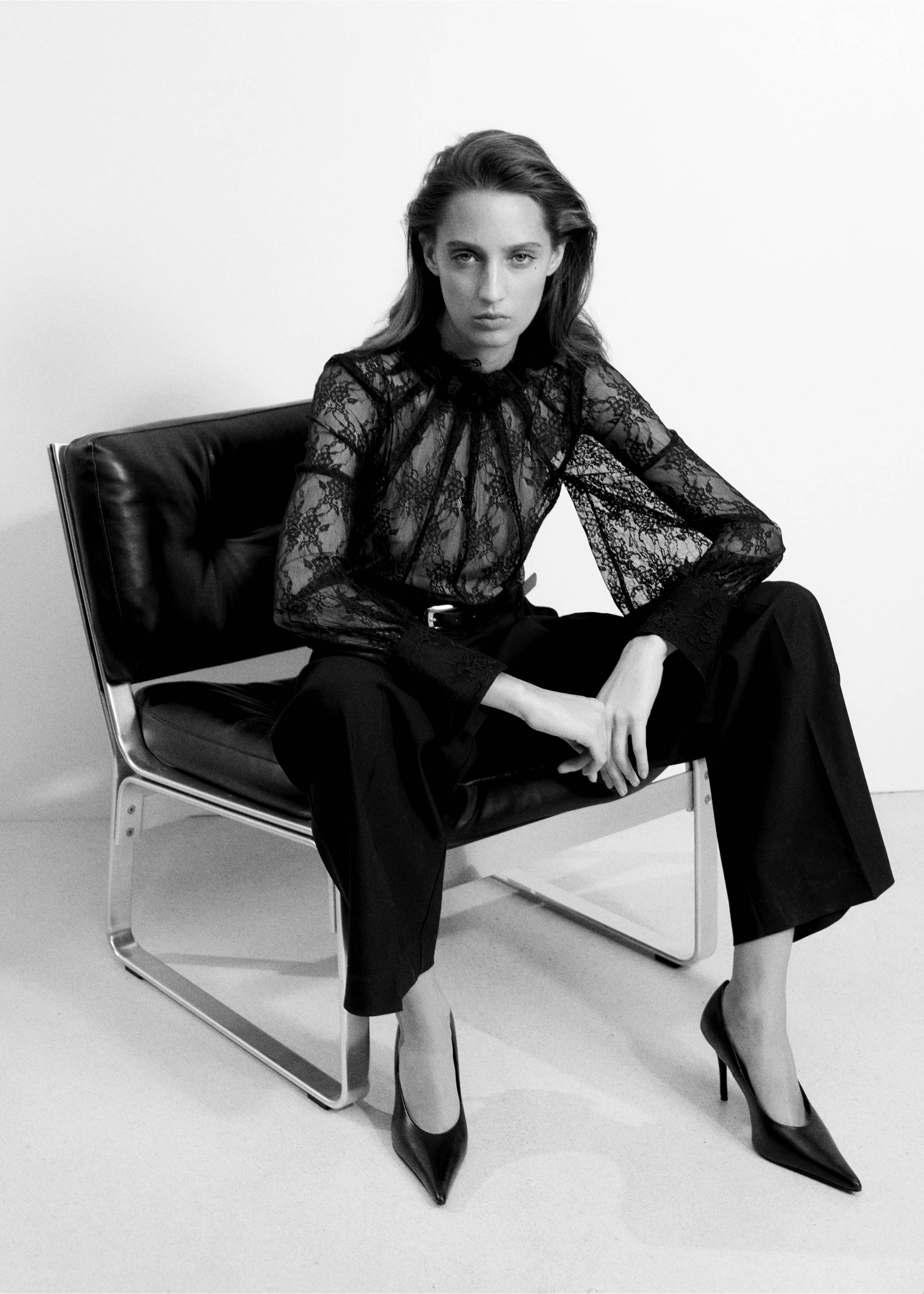 Mono largo de encaje negro con cuello alto con volantes y pantalón ancho, posando sentada., Negro. Ref: 37087784-00.