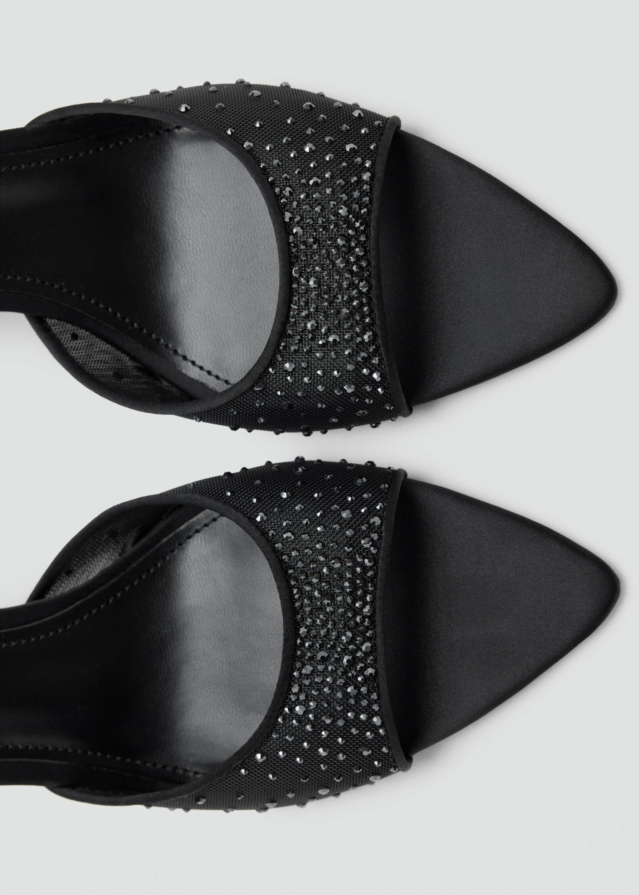 Black sandals with pointed toes and rhinestone-embellished straps.