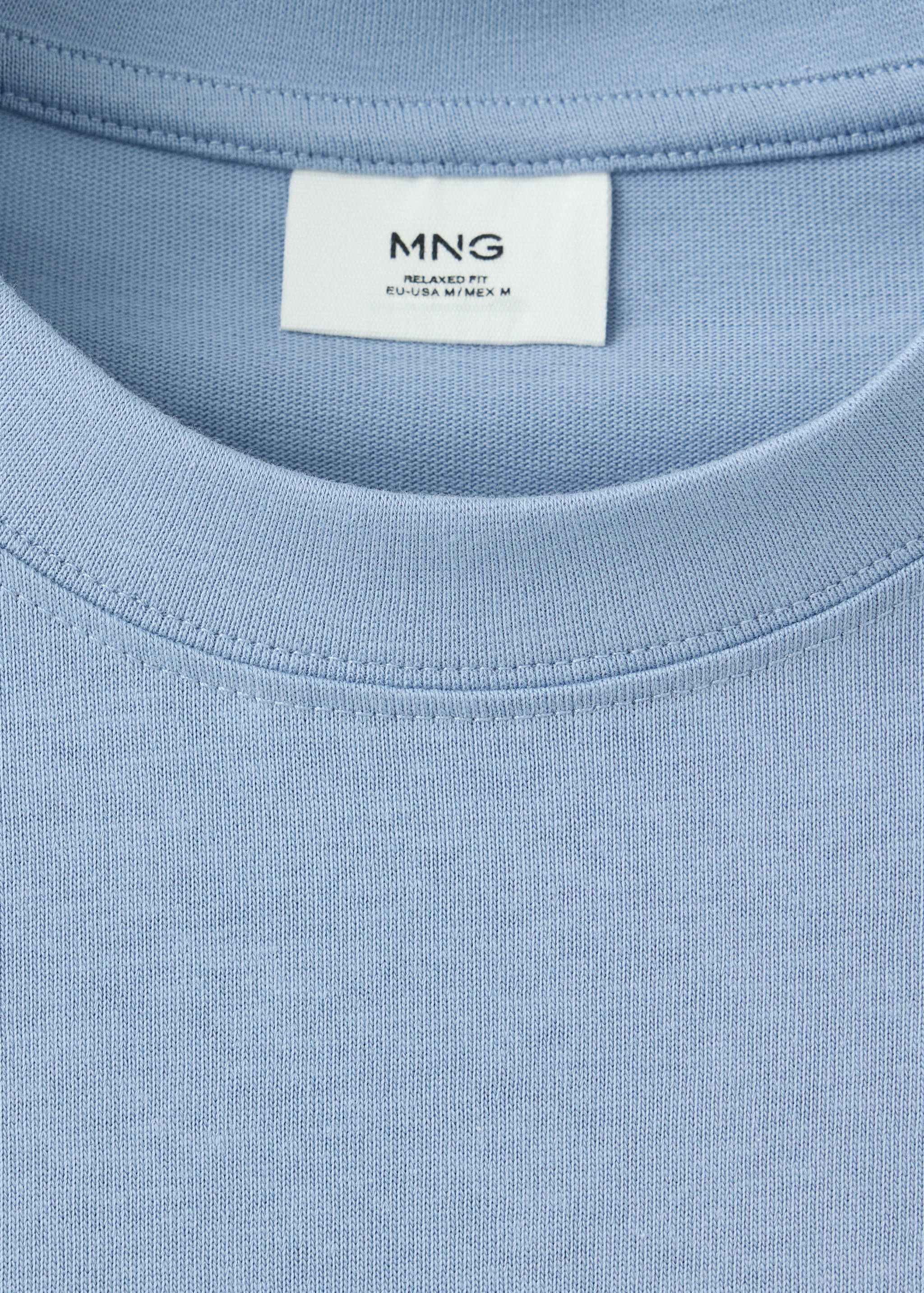 Close-up of a light blue crew neck t-shirt neckline and interior label.