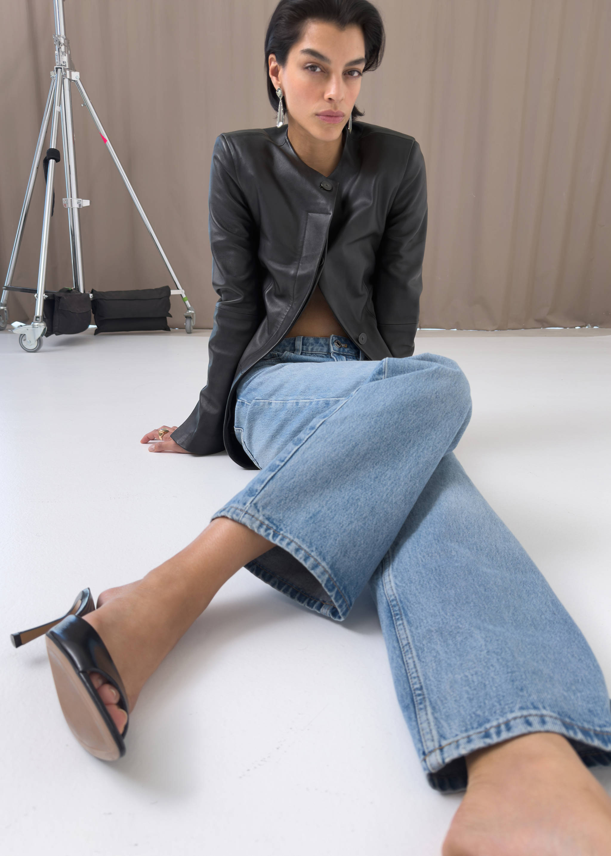 Black heeled sandal with open-toe strap design worn by a seated model., Black. Ref: 37087792-00.