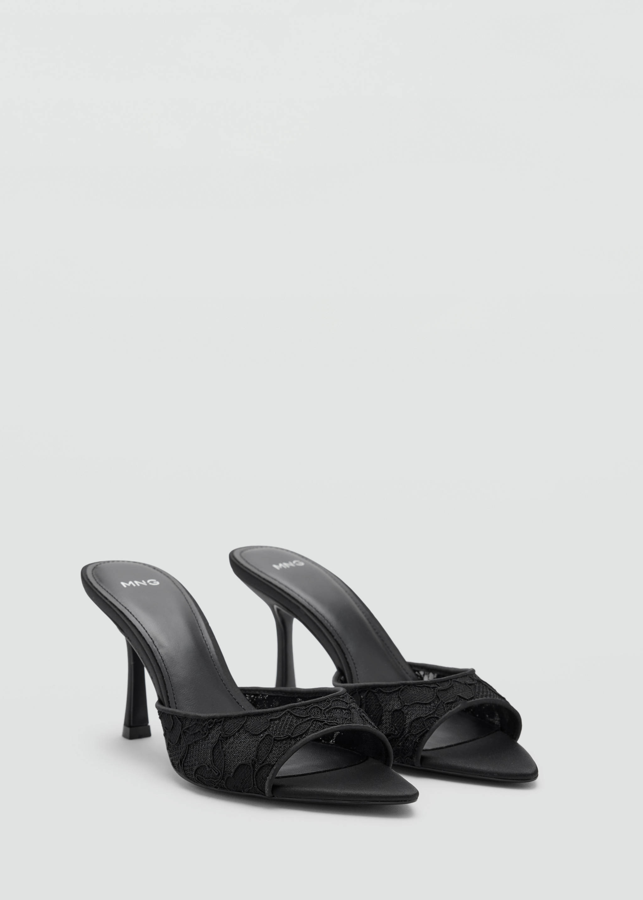 Black heeled sandals with pointed toes, lace front straps and stiletto heels.