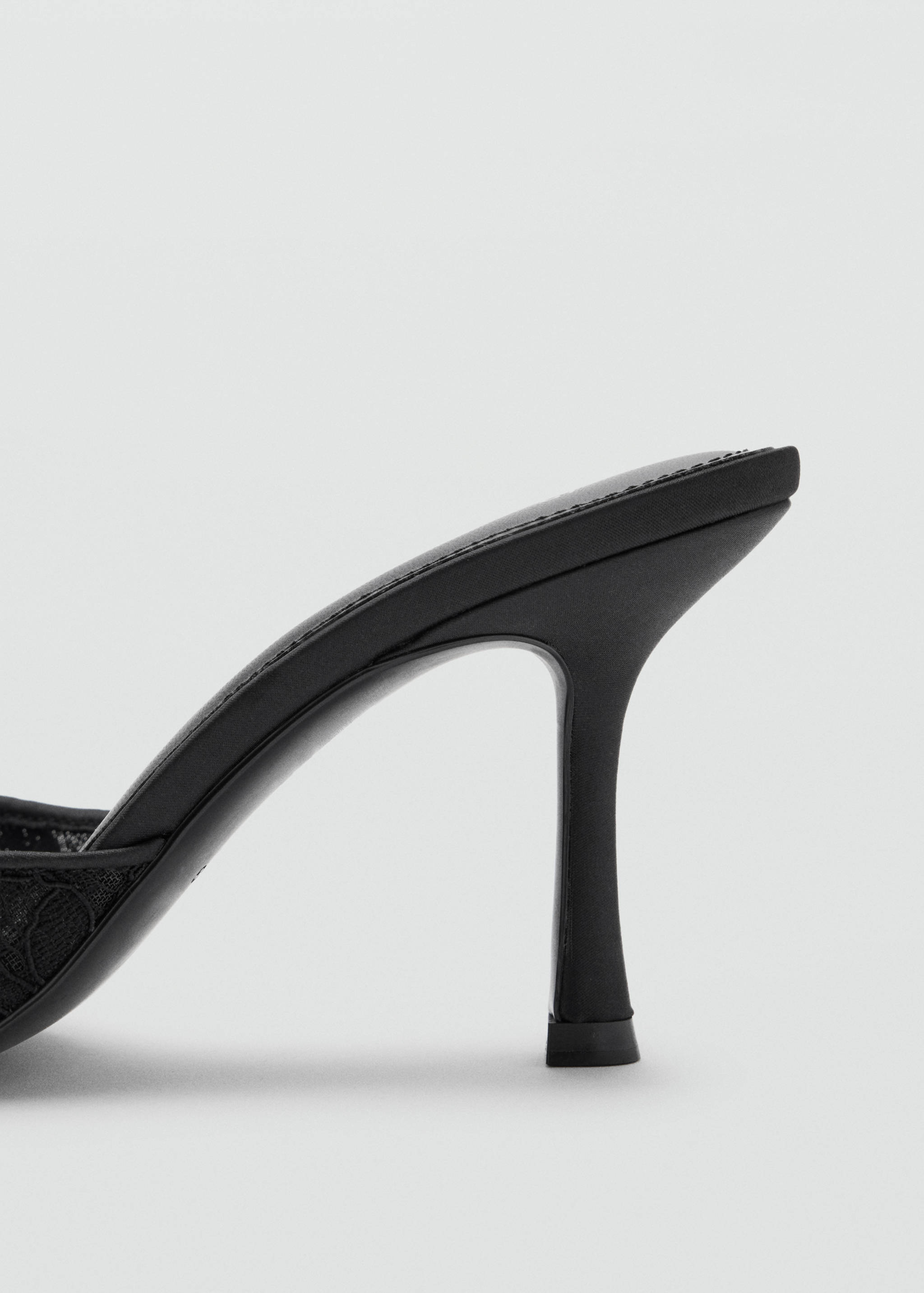 Close-up of a black heeled sandal featuring a slim stiletto heel.