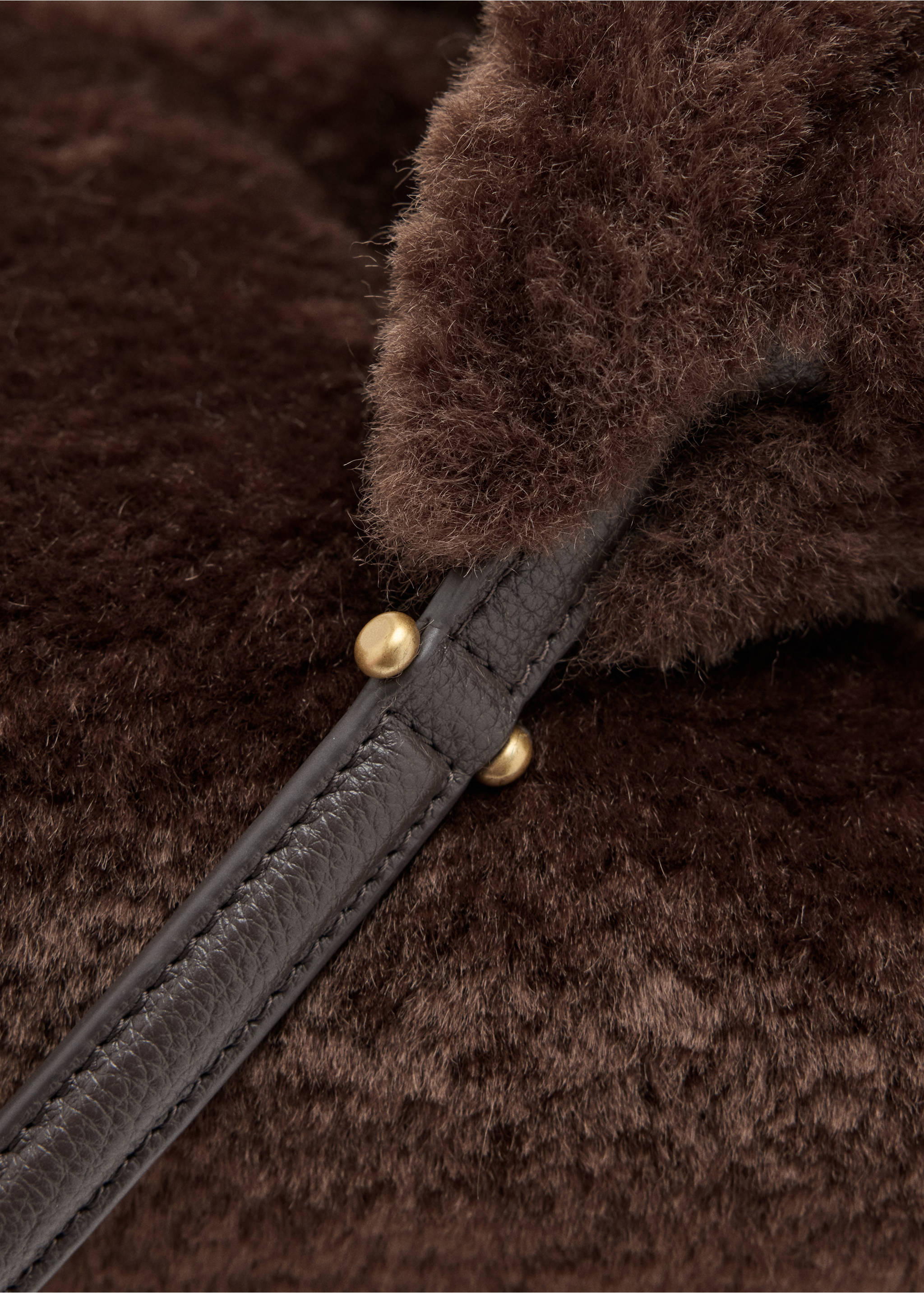 Close-up of a brown faux-shearling bag with a leather strap and gold buttons., Chocolate. Ref: 37087797-00.