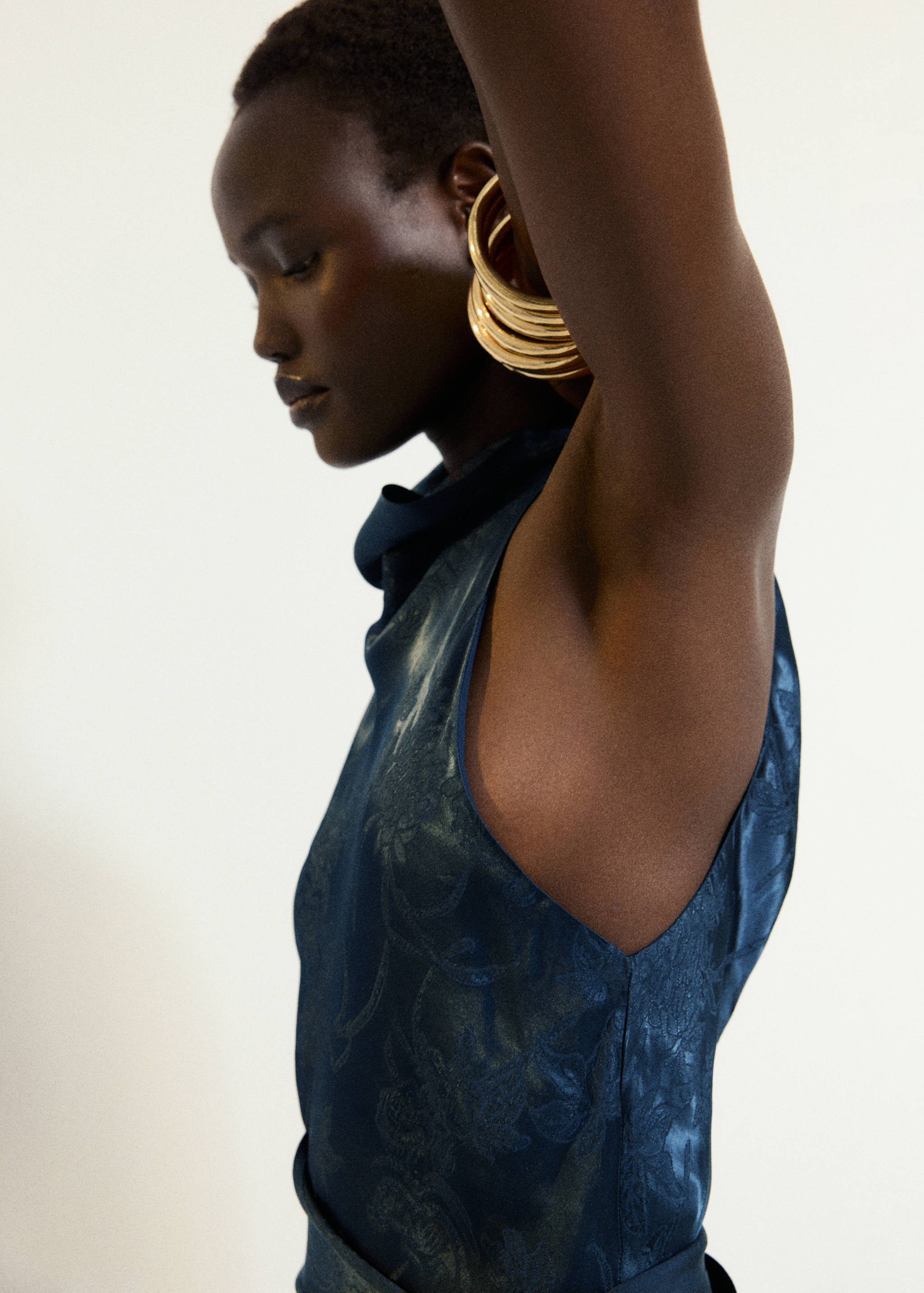 Dark blue sleeveless jumpsuit with a tonal floral pattern, back view.