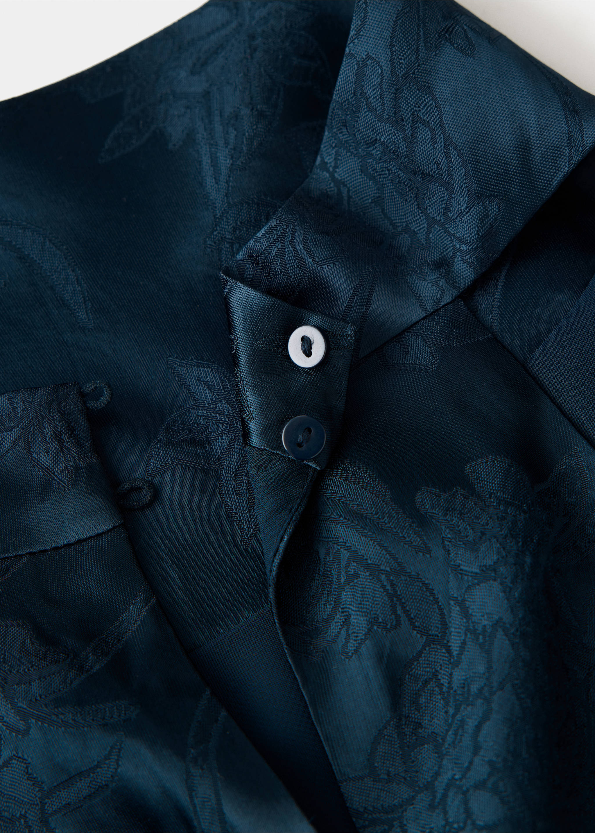 Dark teal jacquard fabric detail of a jumpsuit with a floral pattern and button collar., Navy. Ref: 37087801-00.