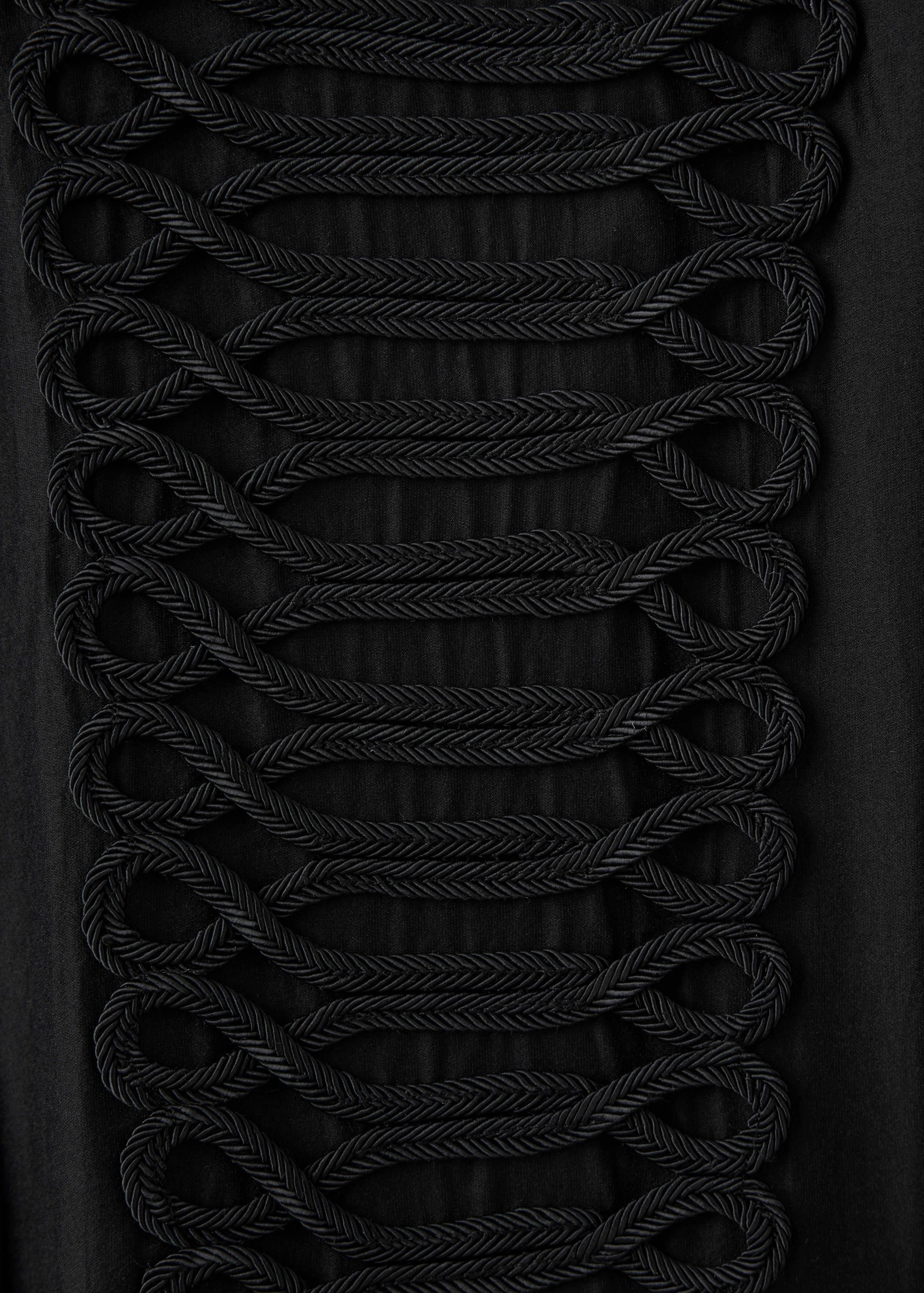 Close-up of a black shirt featuring braided cord embroidery.