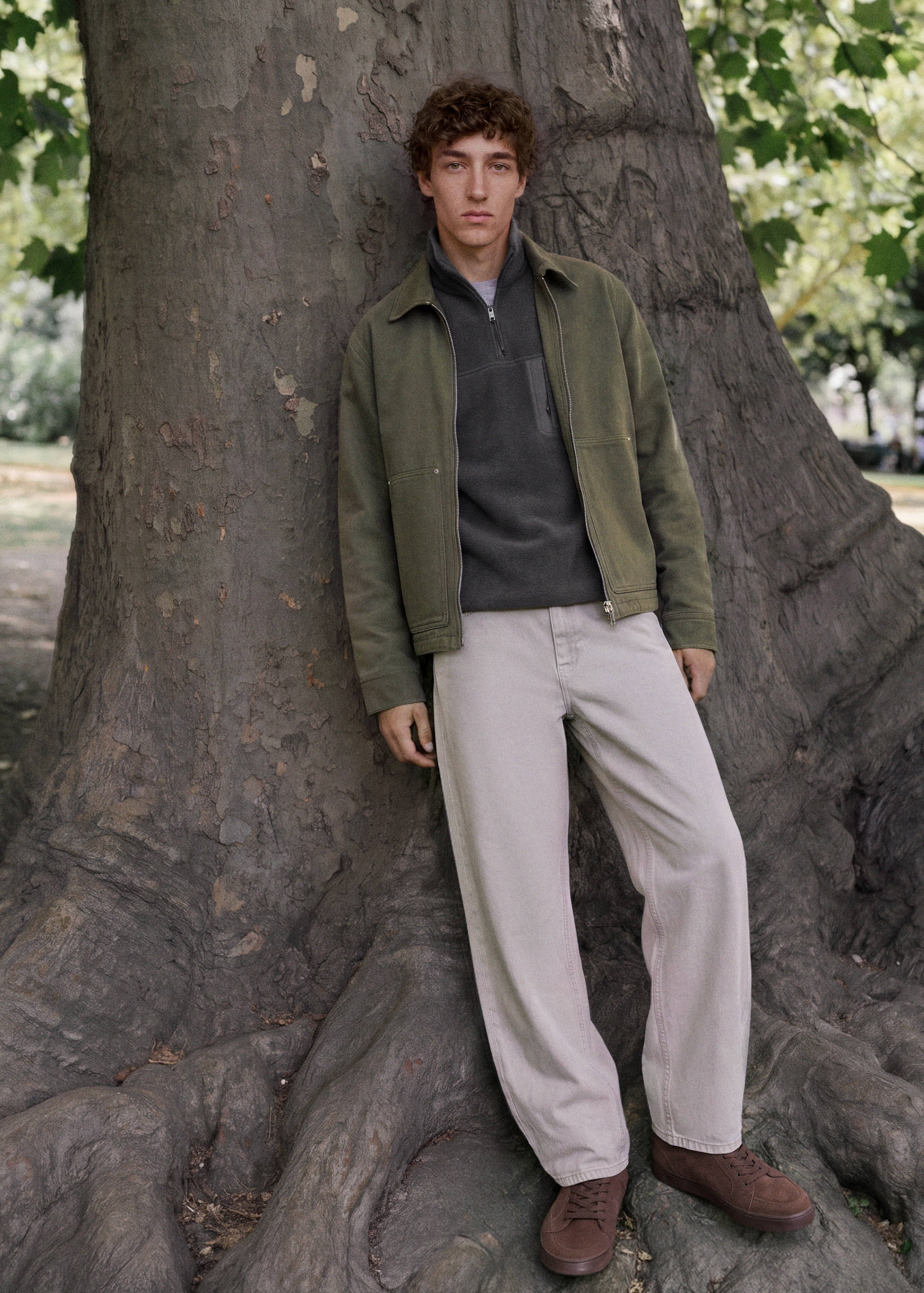 Dark grey half-zip fleece sweatshirt worn with an olive green jacket and trousers