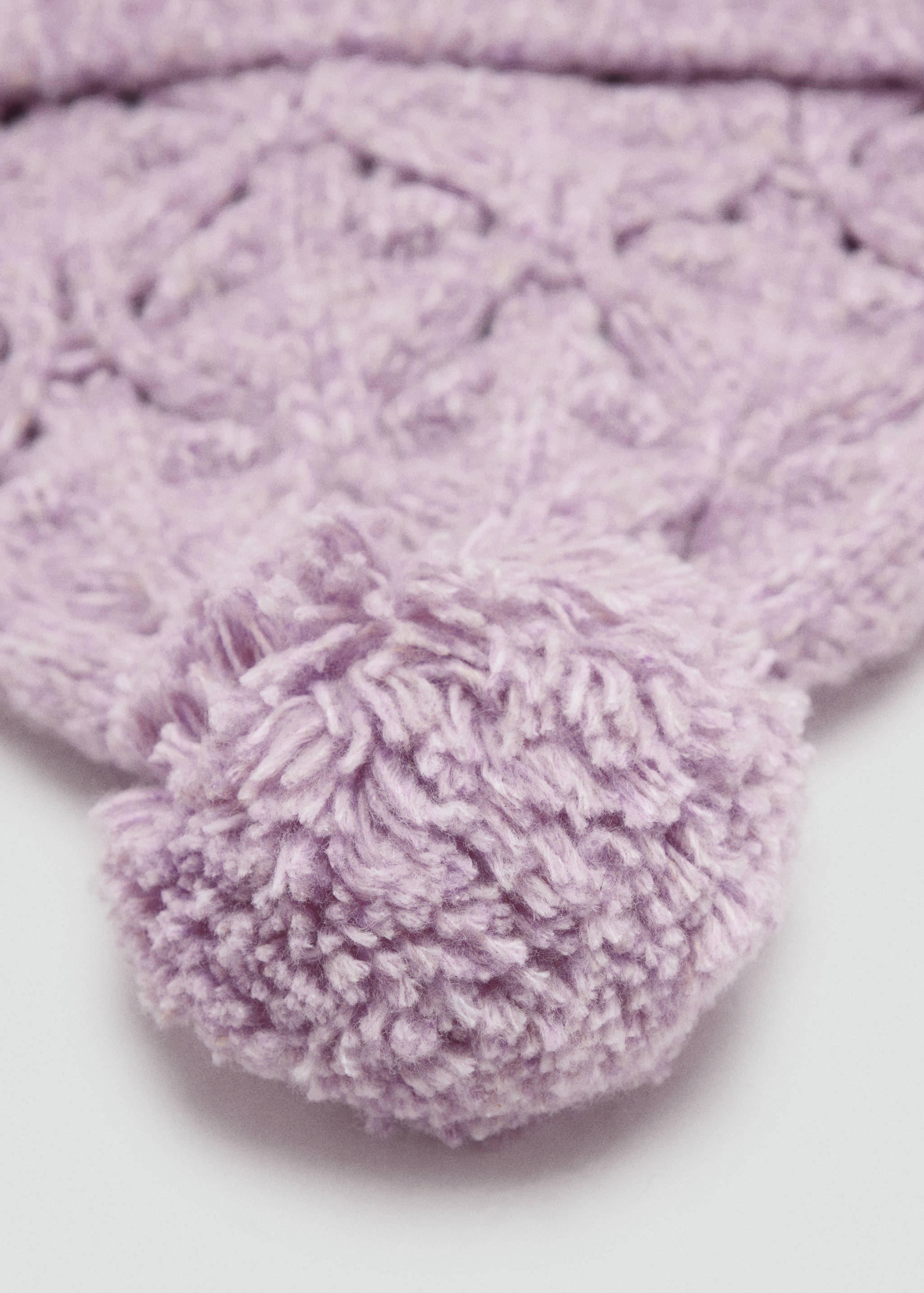 Close-up of a pale purple knitted hat with a pom-pom detail.