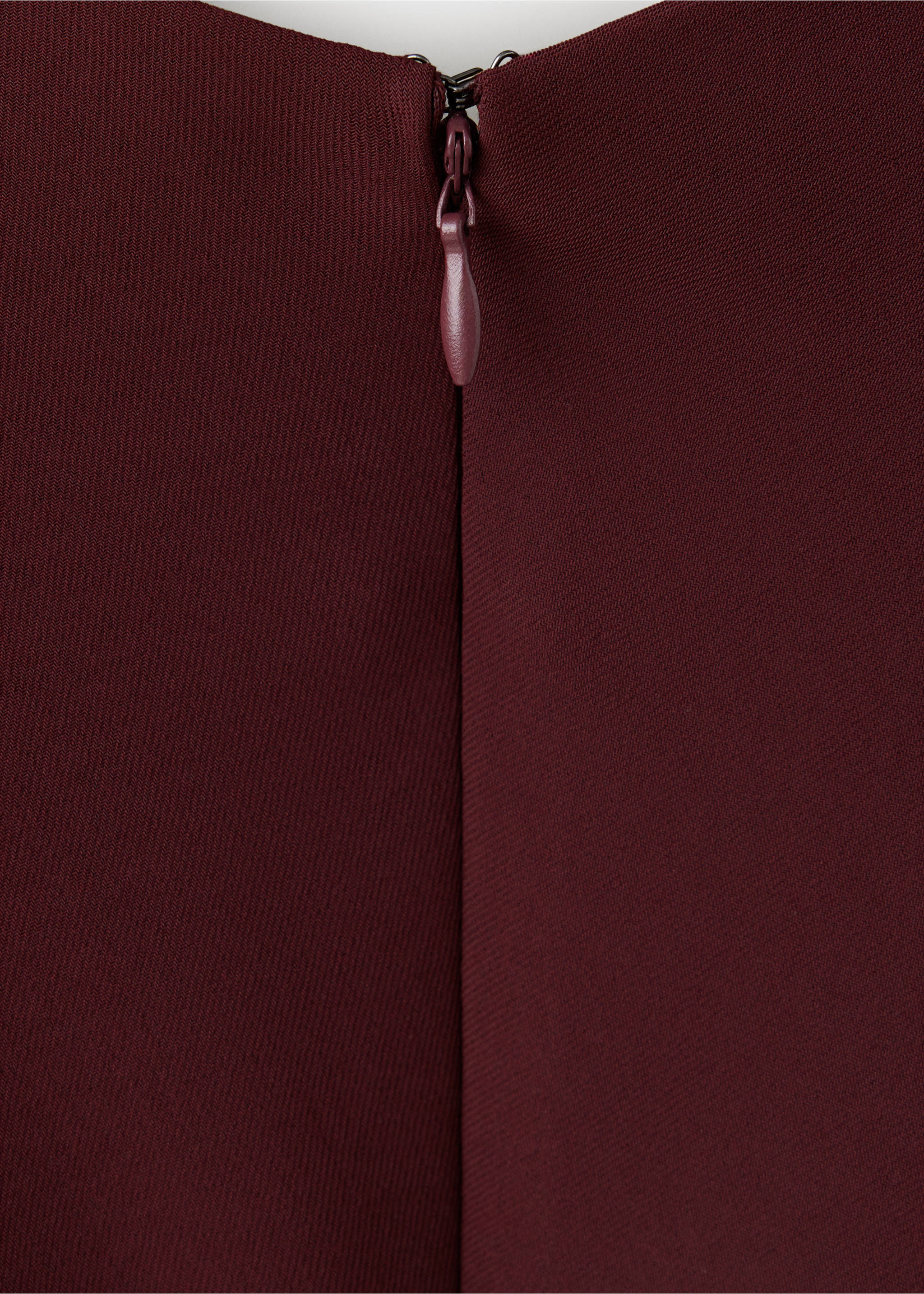 Burgundy dress zip detail showing a concealed zipper and fabric-covered puller., Maroon. Ref: 37087809-00.