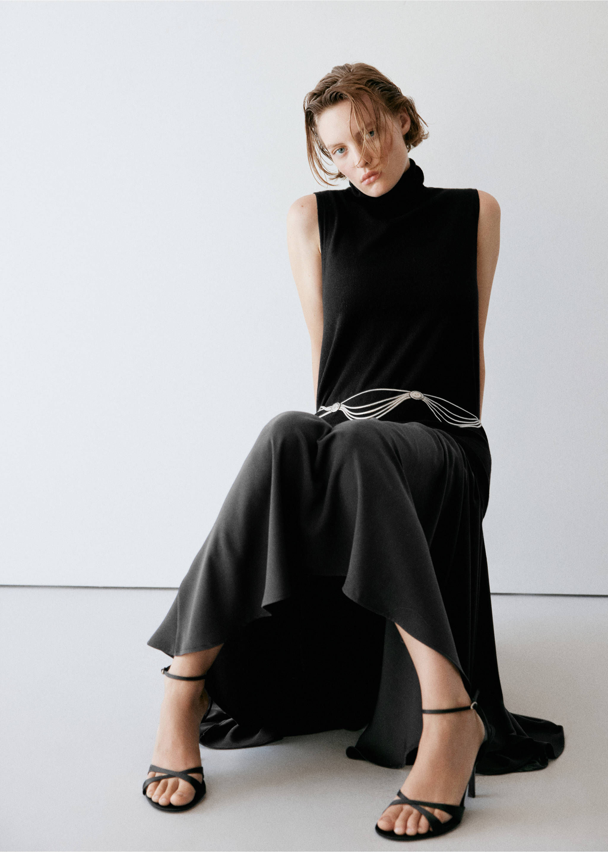 Black sleeveless turtleneck dress with a silver chain belt., Black. Ref: 37087811-00.