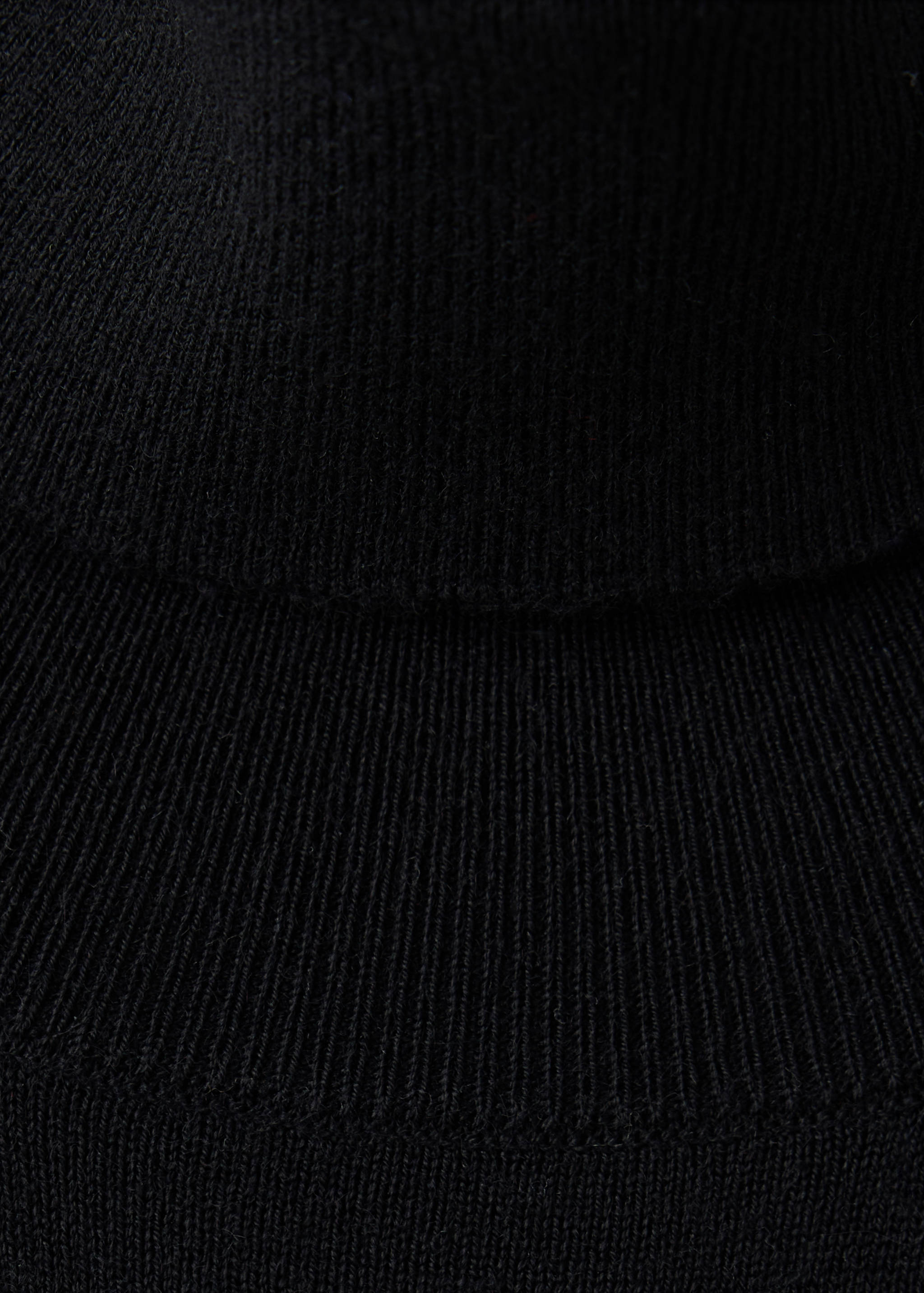 Close-up of black dress fabric showing fine ribbed knit detail.