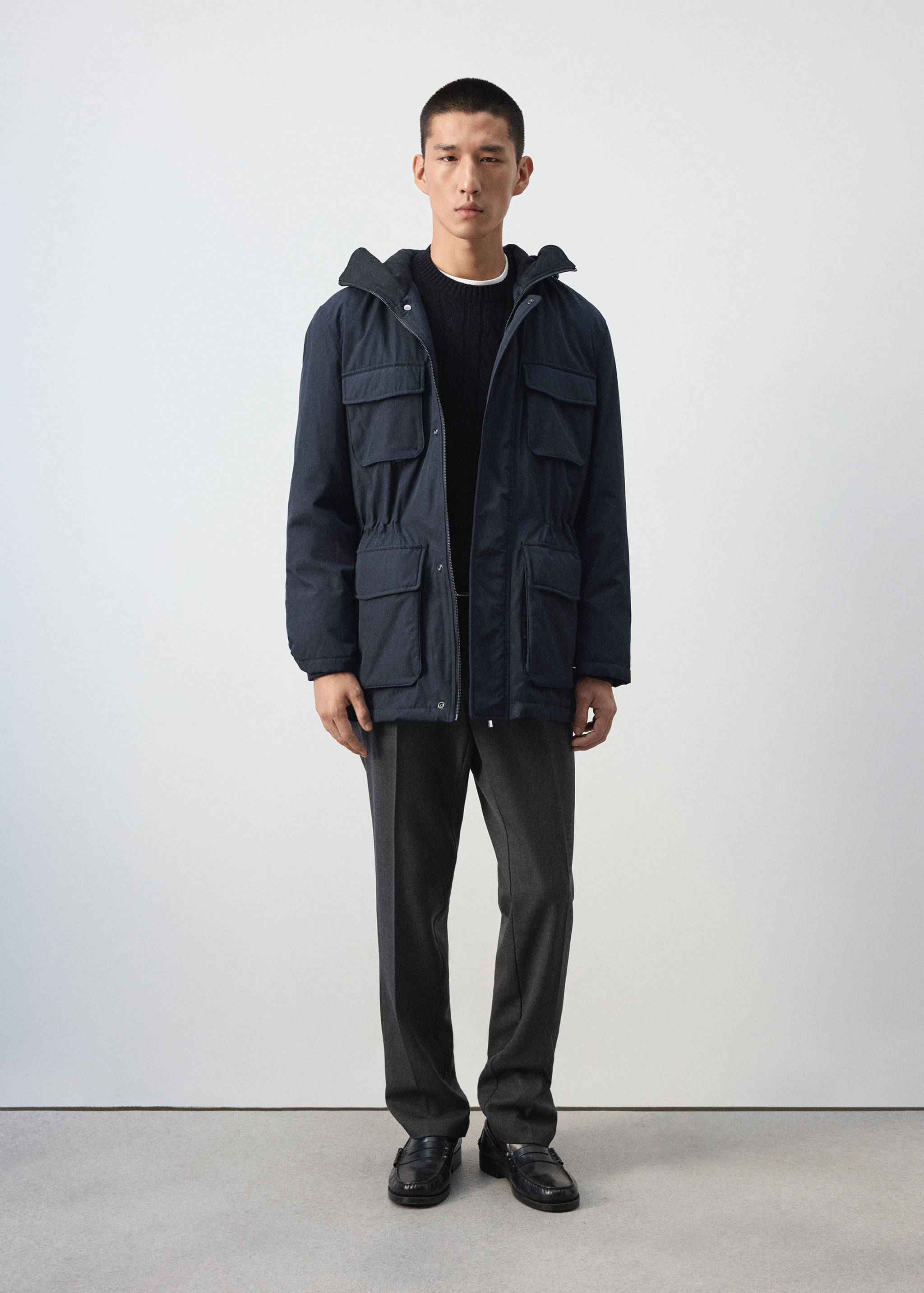 Dark navy parka with a hood, chest flap pockets, and waist pockets.