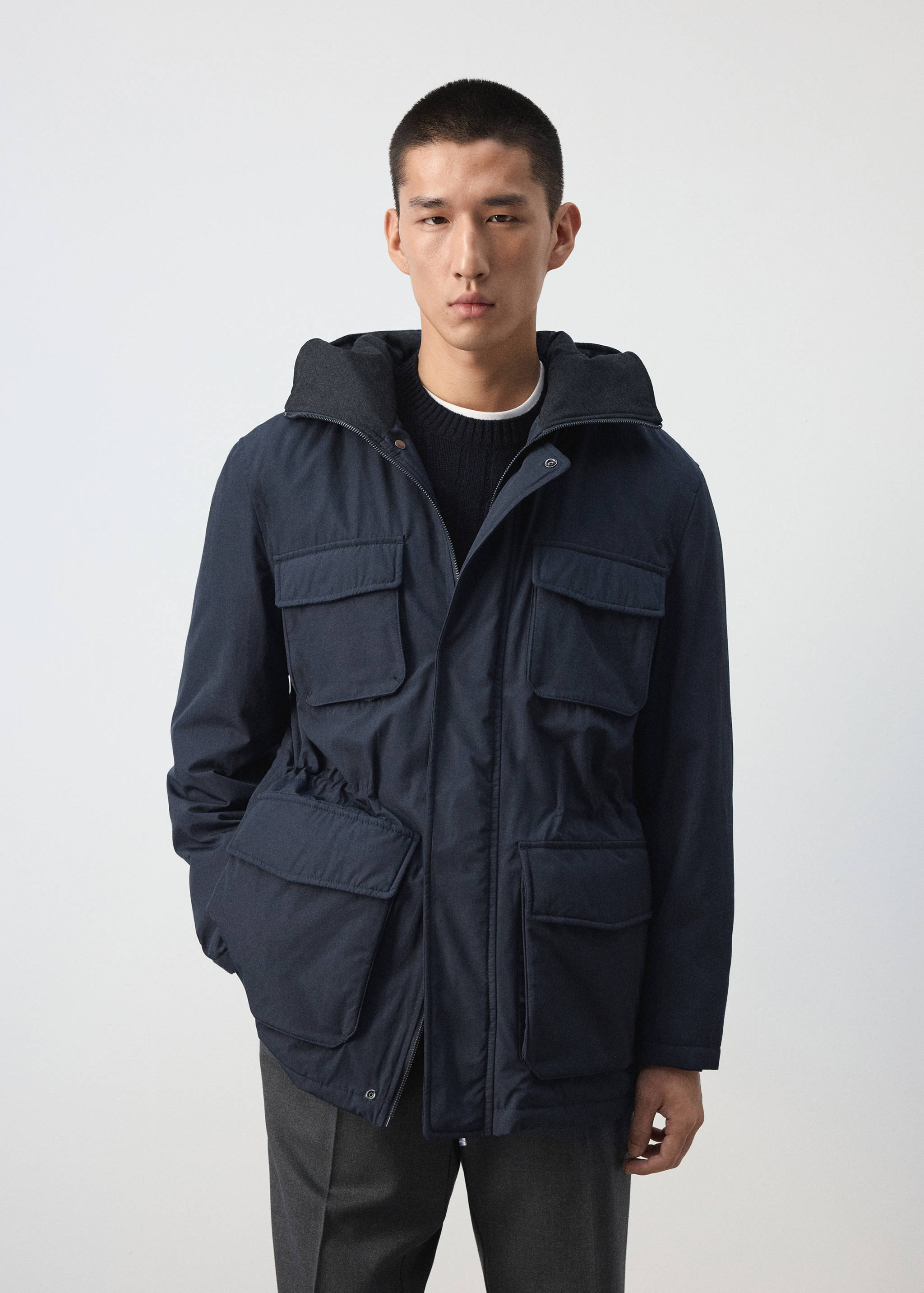 Dark navy blue parka with a hood, flap pockets and a drawstring waist.
