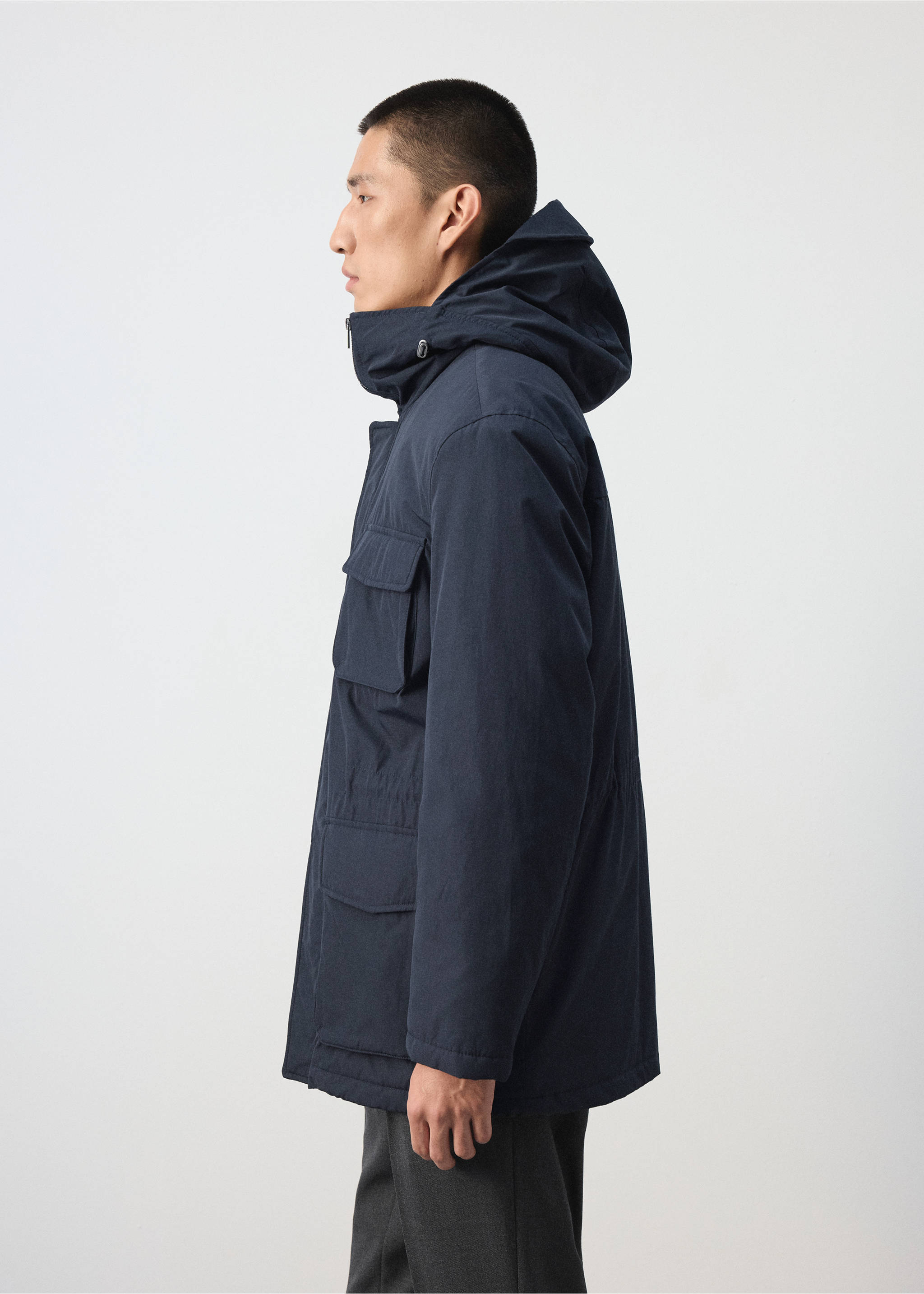 Navy blue hooded parka with utility pockets, shown in profile., Night Blue. Ref: 37087883-00.