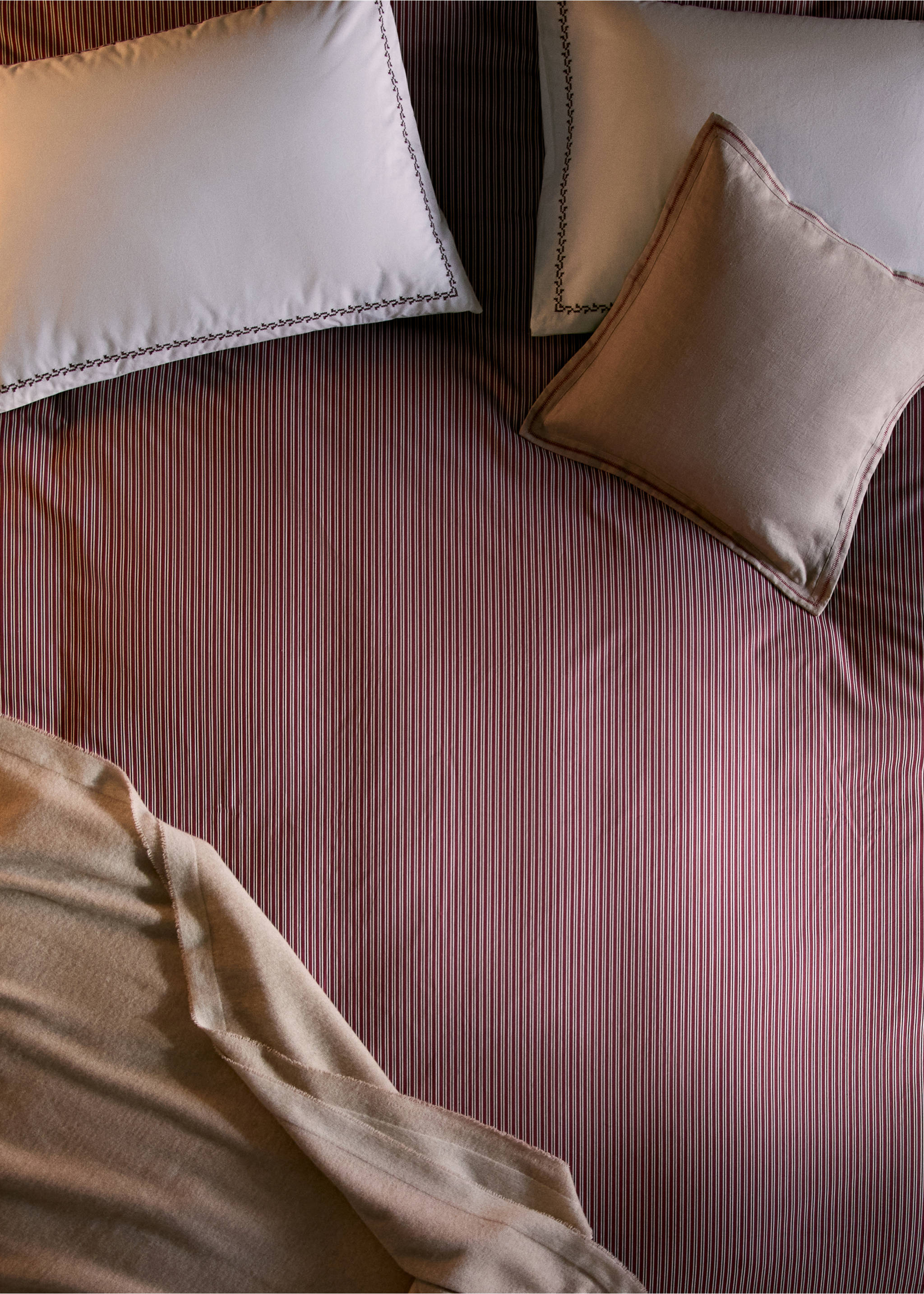 Burgundy and white striped duvet cover styled on a bed with pillows and a throw., Red. Ref: 37087887-00.