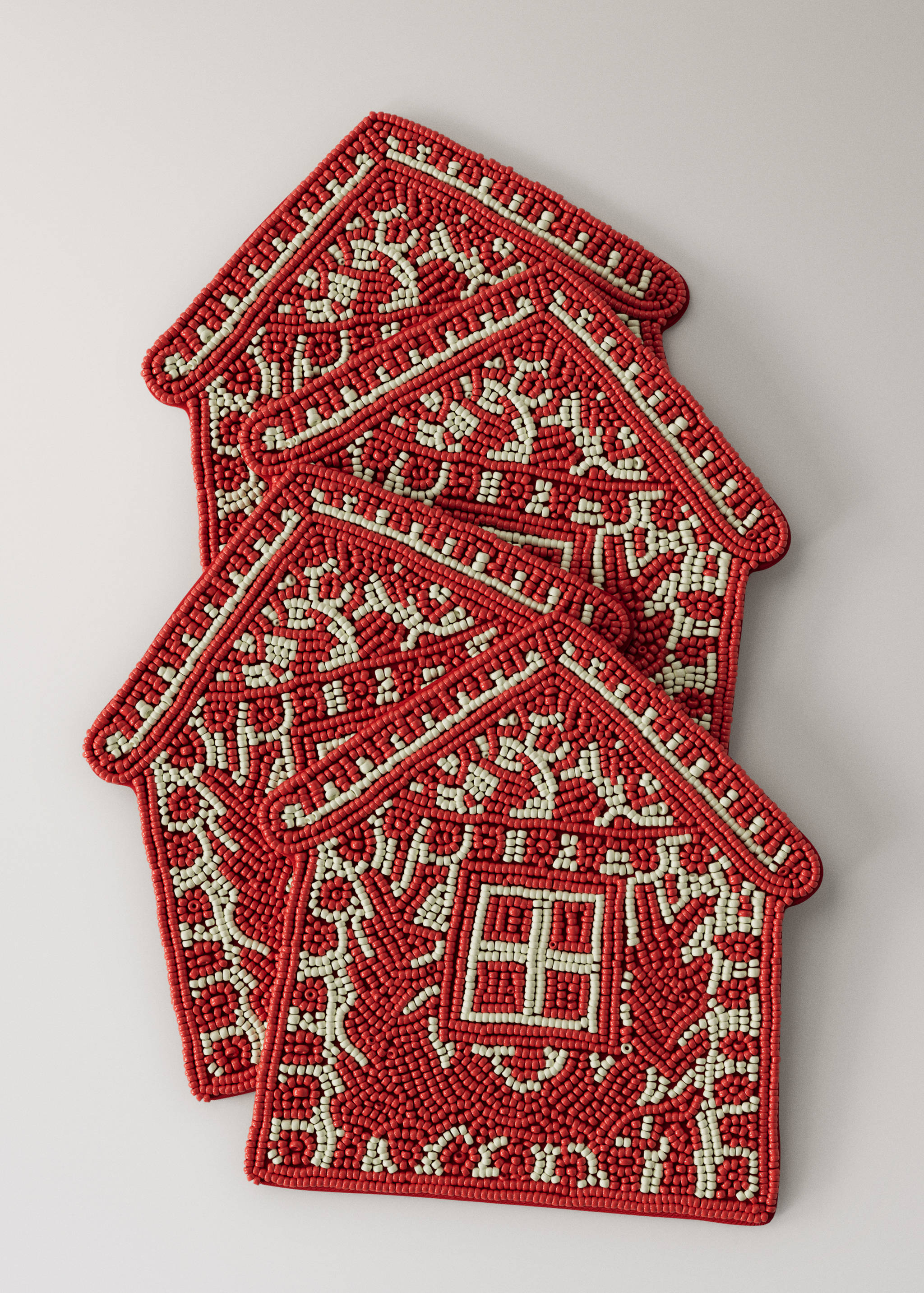Set of four red and white beaded house-shaped coasters with intricate patterns.