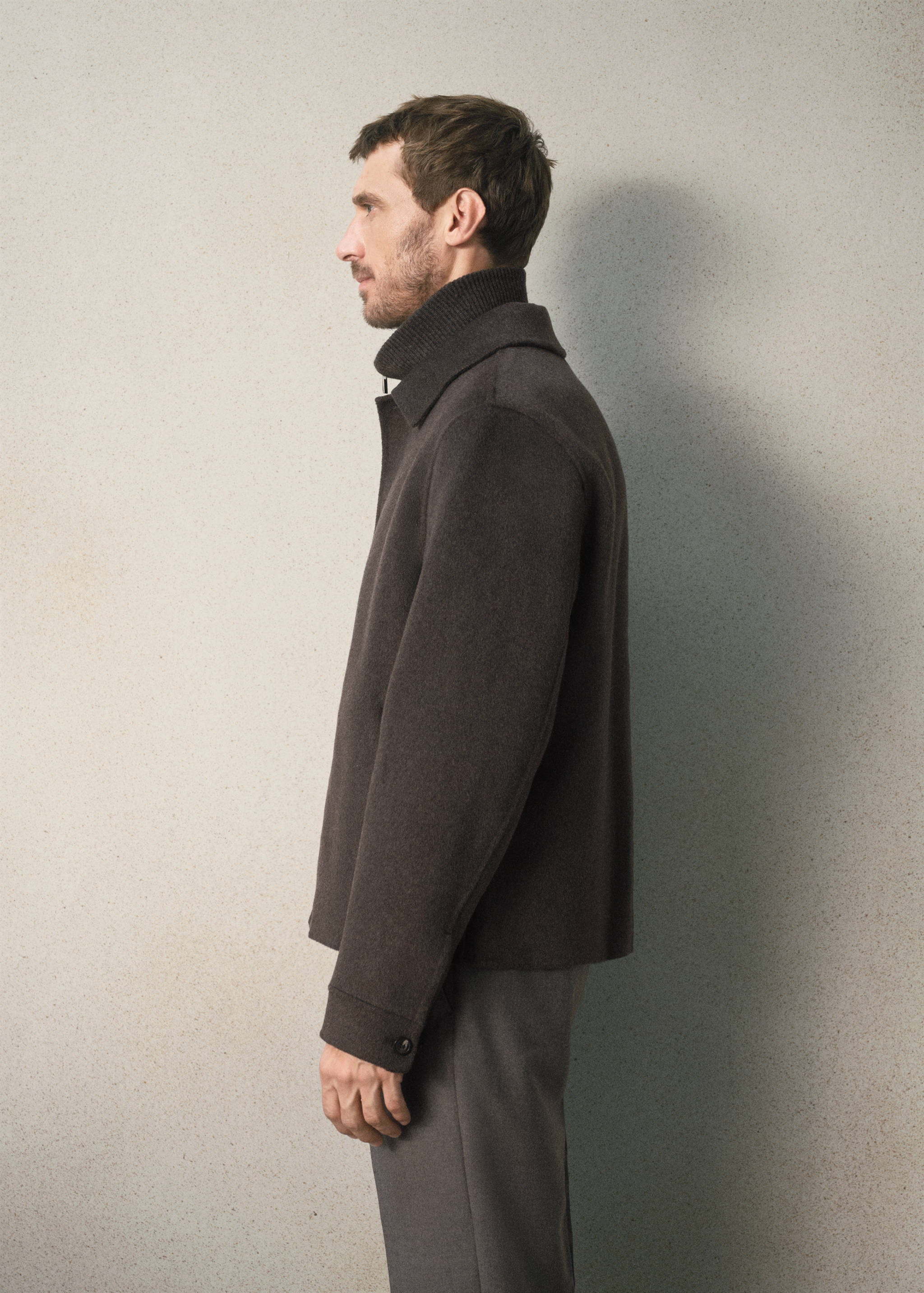 Dark brown jacket with a classic collar and buttoned cuffs.