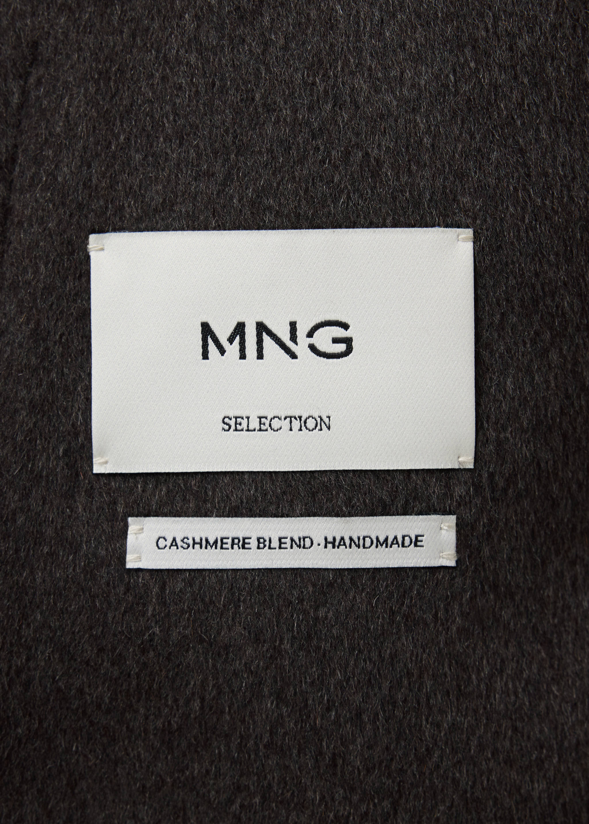 Close-up of the fabric and labels inside a dark grey jacket.
