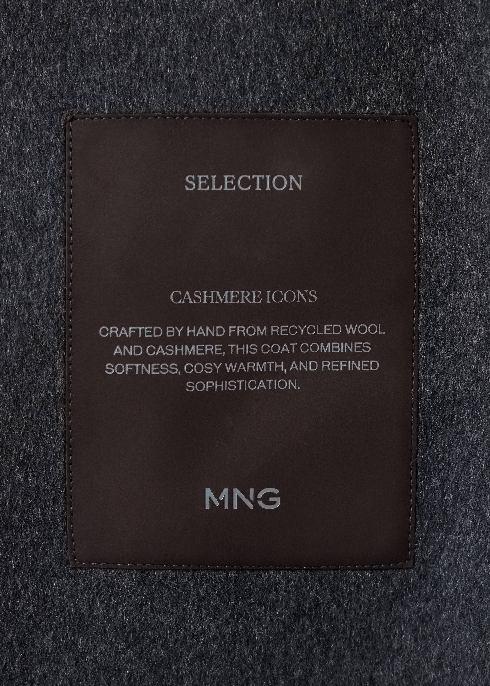 Close-up of the fabric and interior label on a dark grey coat.