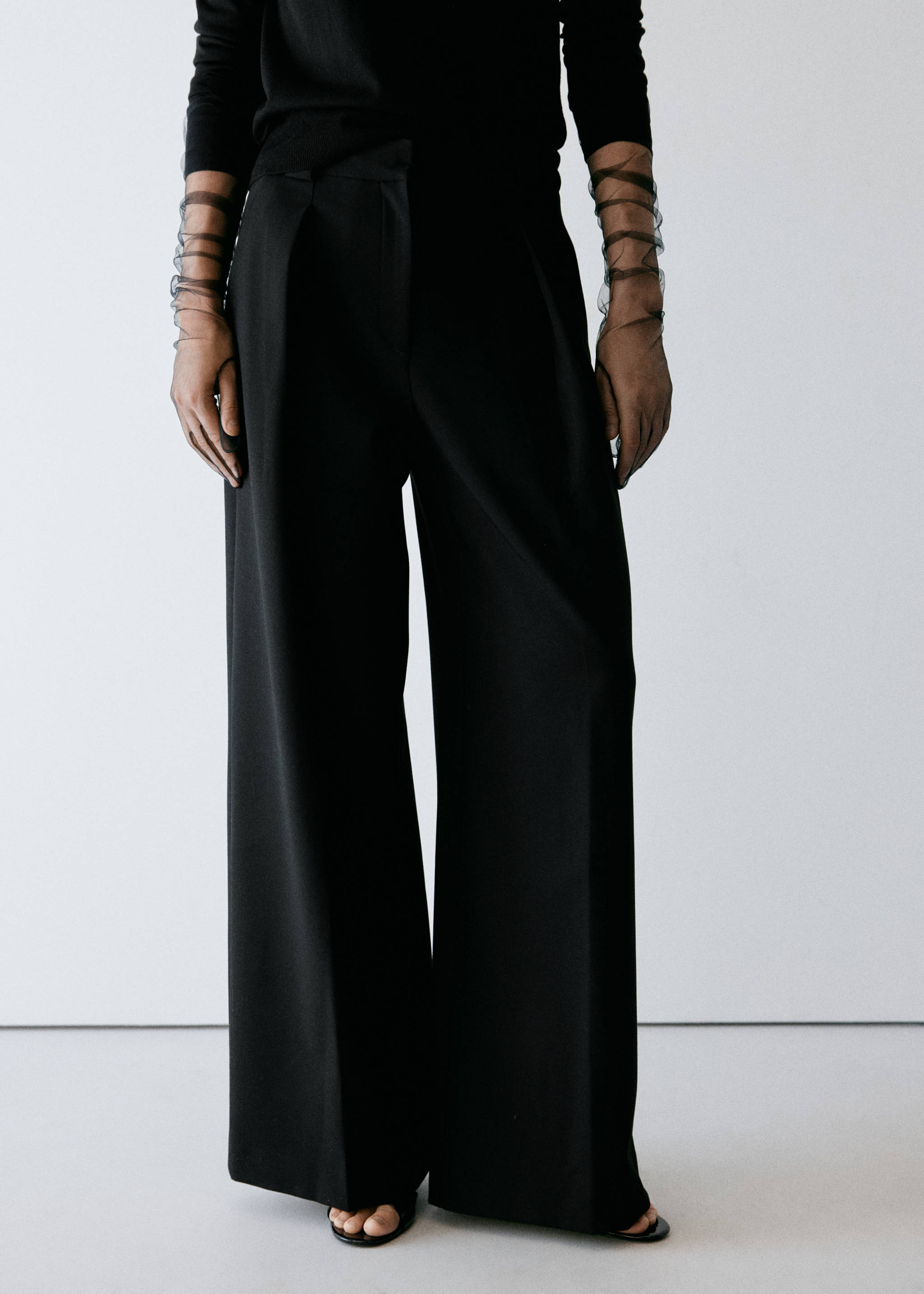 Black wide-leg trousers with front pleats.